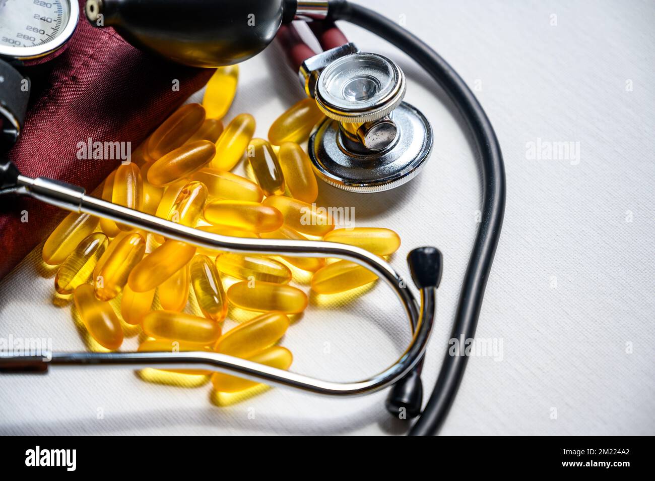 Omega 3 integratori di olio di pesce con stetoscopio e bracciale per la pressione sanguigna Foto Stock