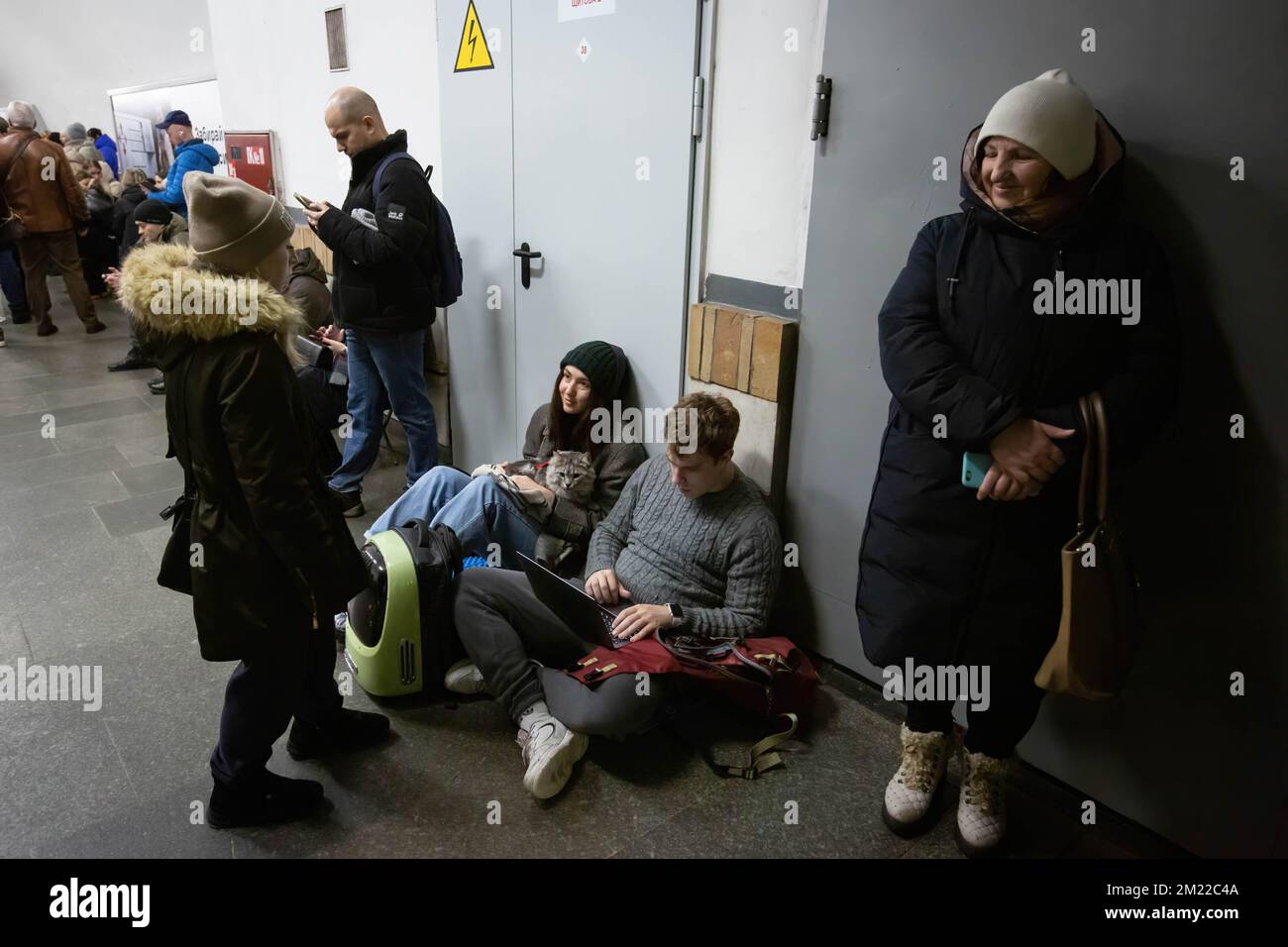 Kiev, Ucraina. 13th Dec, 2022. Si vede una giovane donna che trasporta un gatto e un uomo viene visto su un computer portatile che passa del tempo all'interno di una stazione della metropolitana durante un allarme raid aereo nel centro di Kyiv. I civili usano le stazioni della metropolitana di Kyiv come rifugio durante le incursioni aeree. (Foto di Oleksii Chumachenko/SOPA Image/Sipa USA) Credit: Sipa USA/Alamy Live News Foto Stock