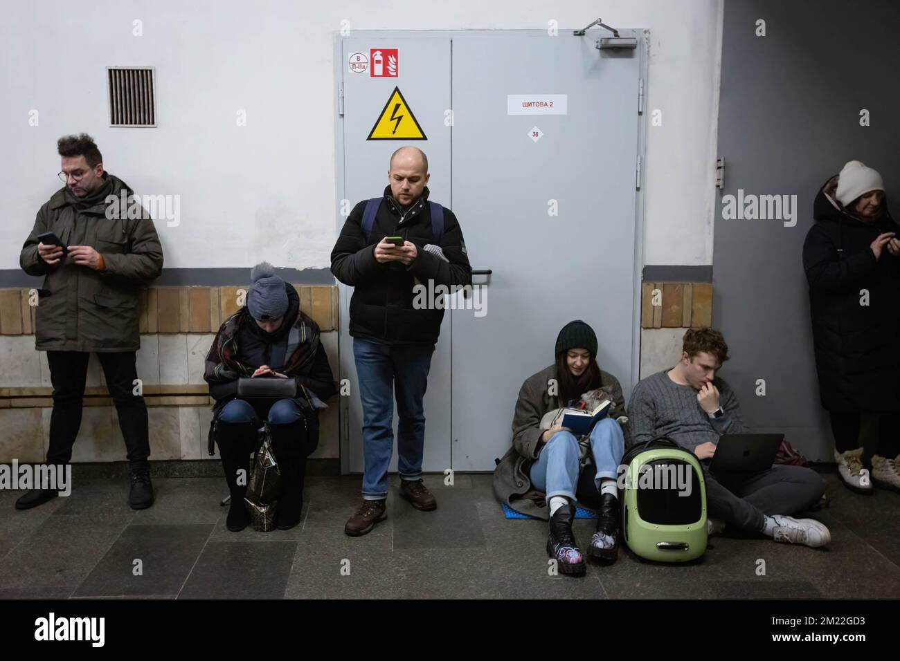 Kiev, Ucraina. 13th Dec, 2022. Le persone con libri e smartphone trascorrono del tempo all'interno di una stazione della metropolitana durante un allarme raid aereo nel centro di Kiev. I civili usano le stazioni della metropolitana di Kyiv come rifugio durante le incursioni aeree. (Credit Image: © Oleksii Chumachenko/SOPA Images via ZUMA Press Wire) Foto Stock