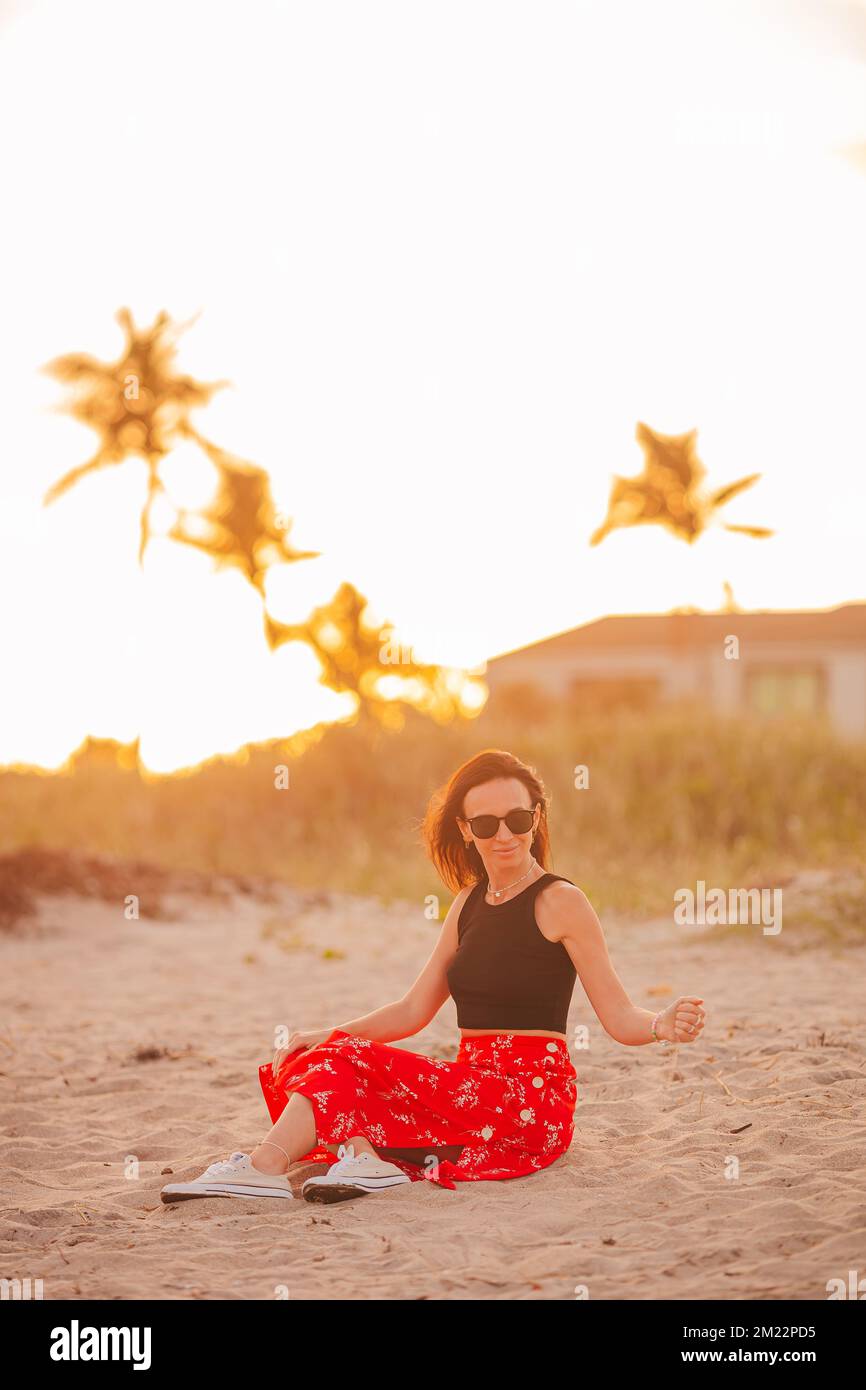 Donna felice godendo bellissimo tramonto sulla spiaggia Foto Stock
