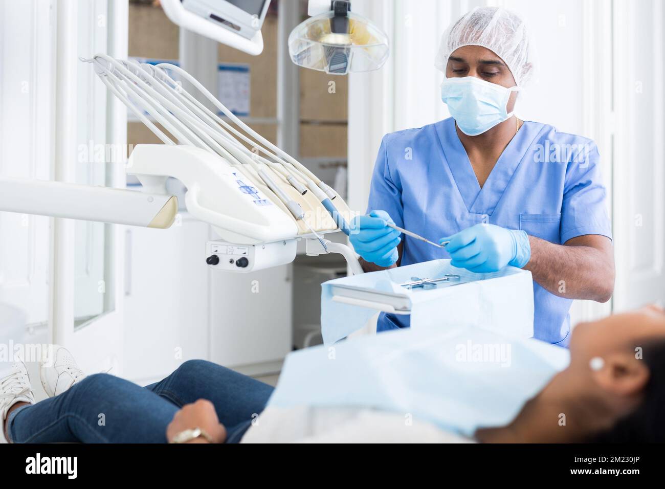 Controllo dentista mirato e disposizione degli strumenti in ufficio dentale Foto Stock