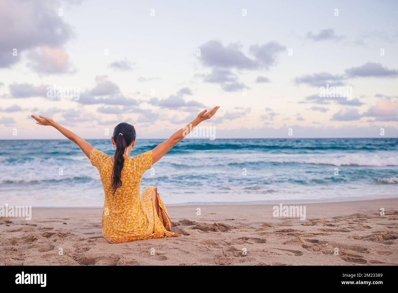 Donna felice godendo bellissimo tramonto con grande luna piena sulla spiaggia Foto Stock
