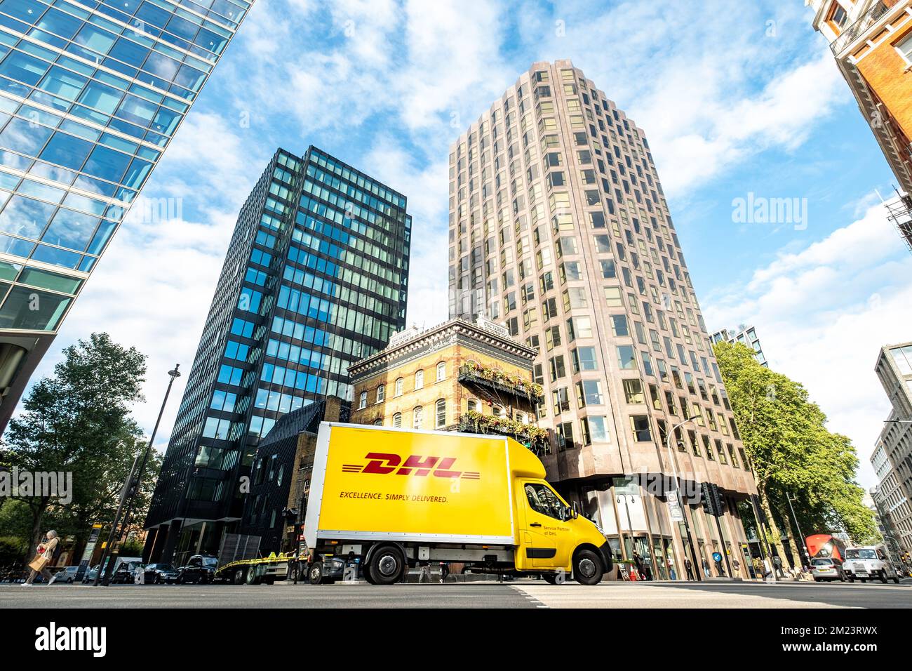 Londra, novembre 2022: Il camion di consegna DHL è alto numero di edifici di uffici londinesi Foto Stock