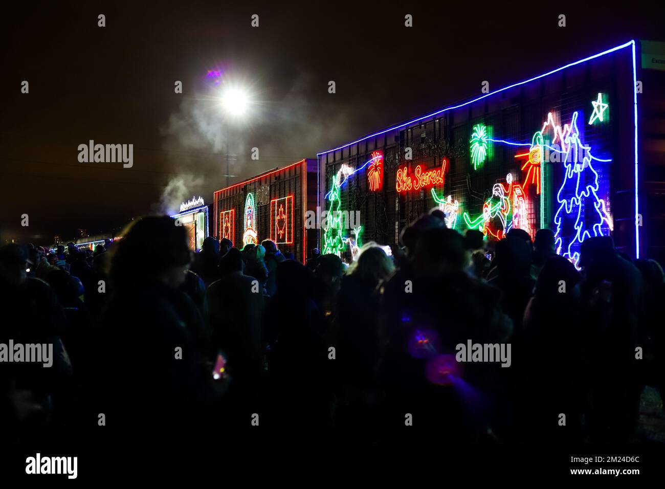 La gente guarda l'arrivo del treno canadese Pacifico ora di Natale, l'illuminazione al neon sulle vetture del treno. Il Train organizza un concerto di beneficenza per vari tipi di carattere Foto Stock