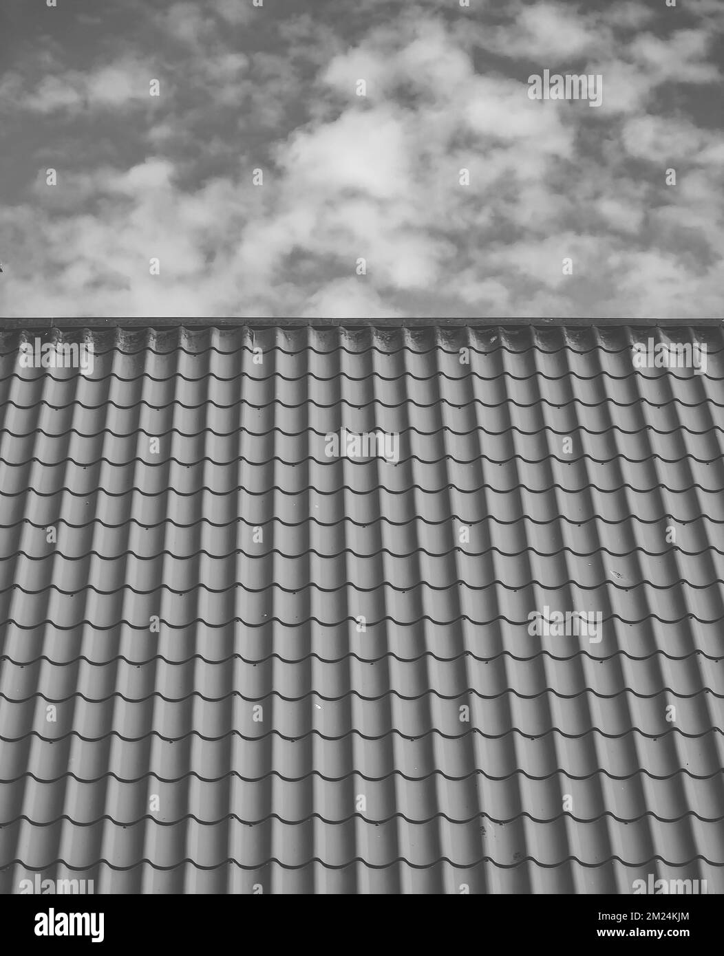 Tetto con tegole rosse. Nuvole nel cielo blu. Primo piano Foto Stock