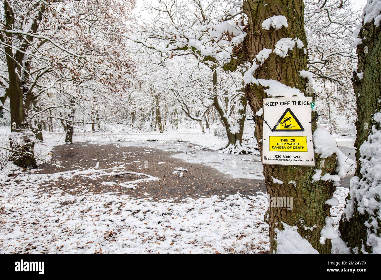 Hampstead Heath ha un certo numero di stagni che pone un pericolo annegante.segni gialli e rossi chiari di avvertimento di morte, raffigurati da uno dei stagni di congelamento Foto Stock