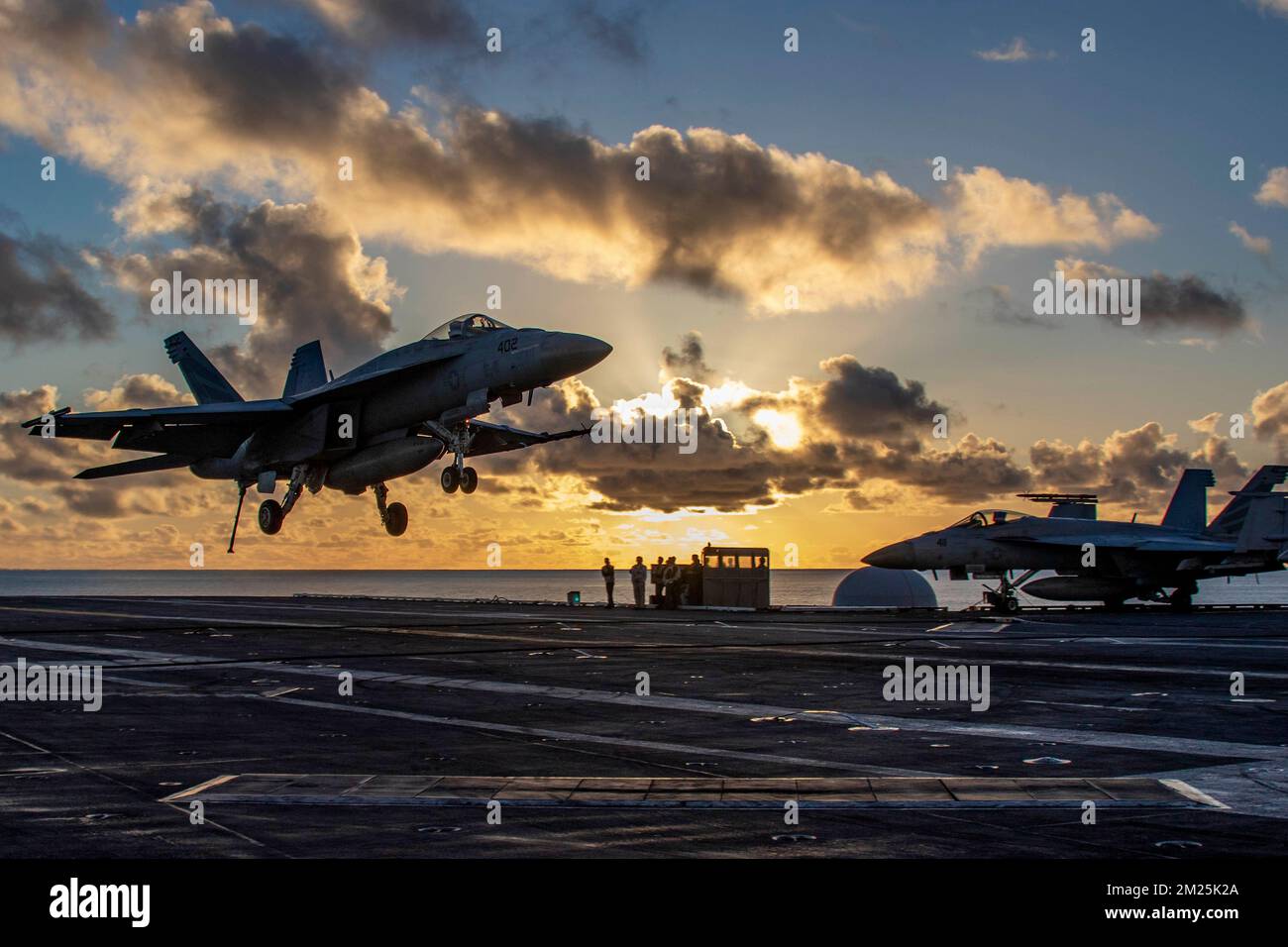 San Diego, Stati Uniti. 07 dicembre 2022. STATI UNITI Navy F/A-18E Super Hornet fighter Aircraft, con i vigilantes di Strike Fighter Squadron 151 si avvicina per l'atterraggio al tramonto sul ponte di volo della portaerei di classe Nimitz USS Abraham Lincoln, 7 dicembre 2022 a San Diego, California. Credit: MCS Julia Brockman/Planetpix/Alamy Live News Foto Stock