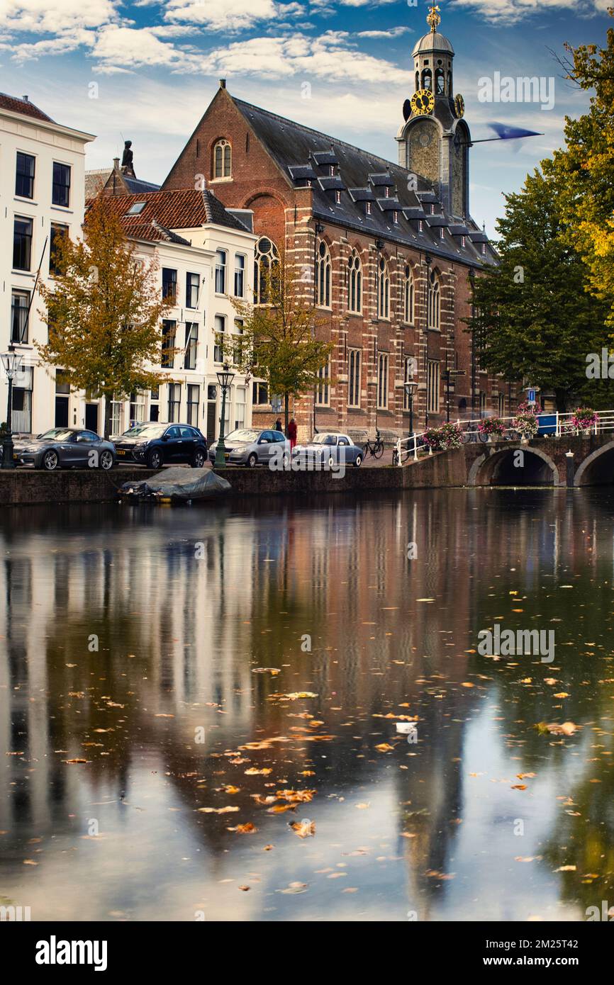 Una foto verticale di una vecchia Università storica con riflessione sull'acqua in autunno, Leiden, Paesi Bassi Foto Stock