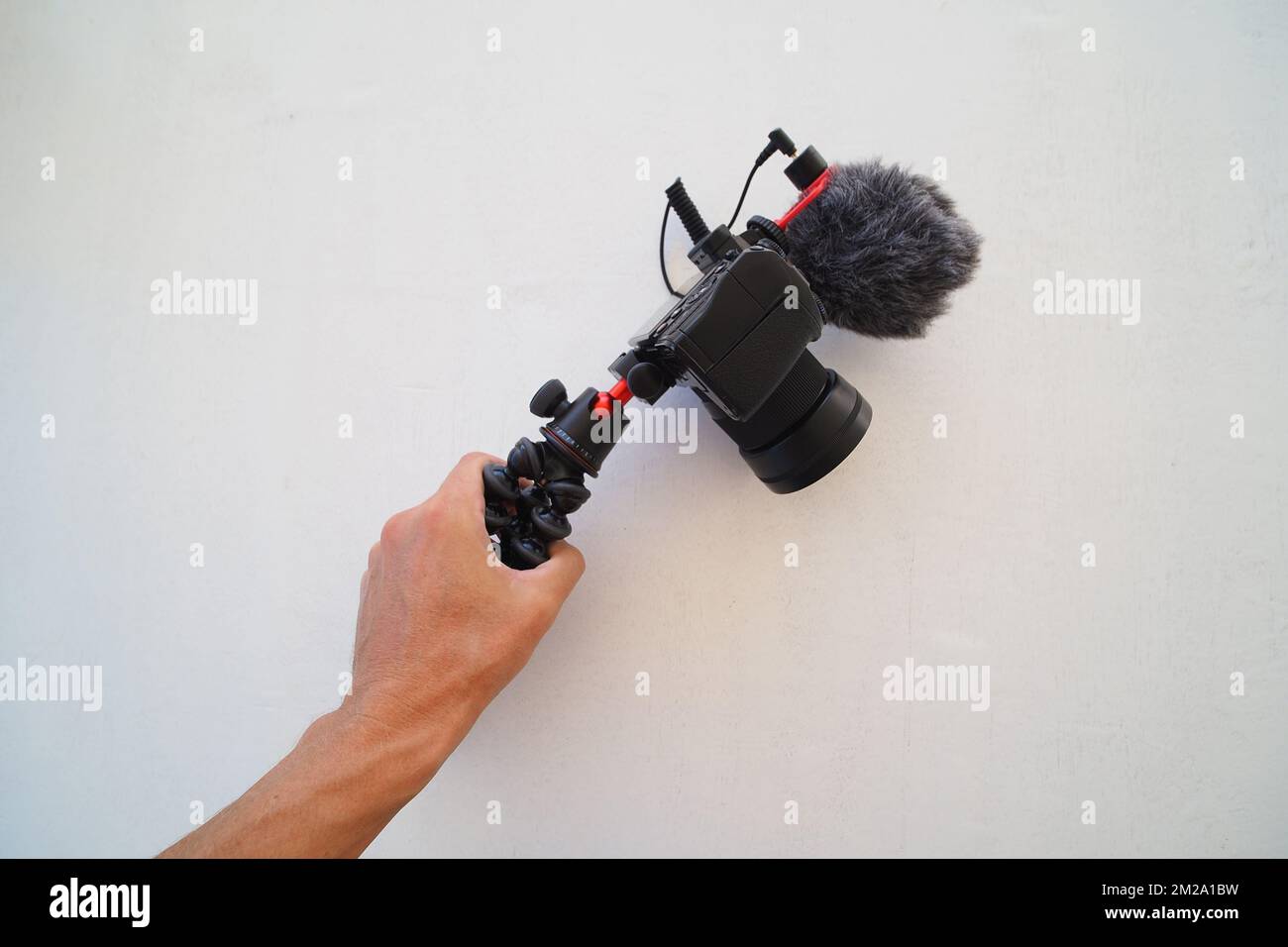 Fotocamera digitale con microfono in mano. Concetto di blogger. Foto Stock