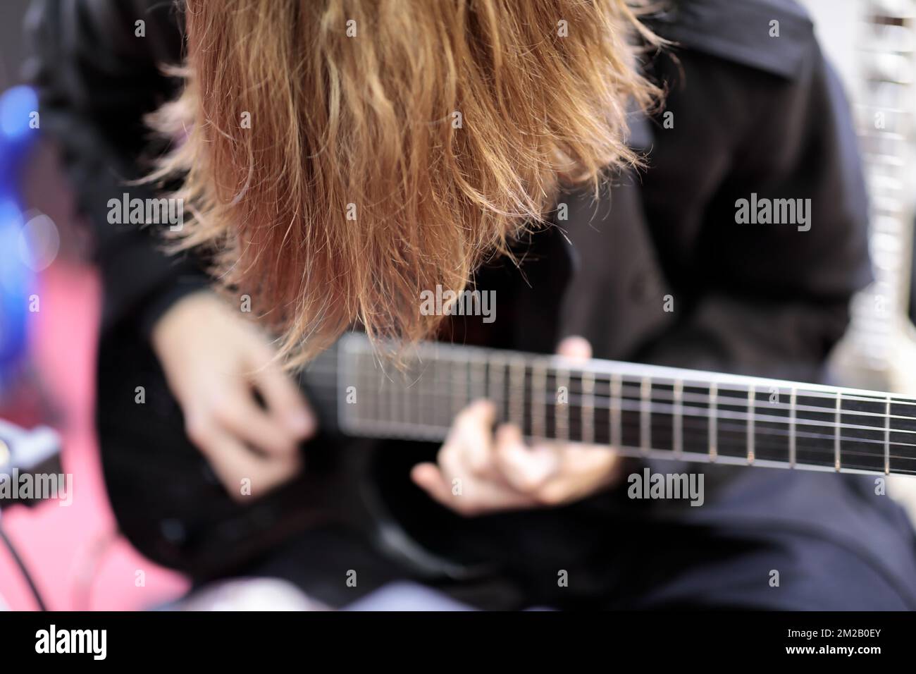 Chitarrista Long hair rock che suona chitarra elettrica. Messa a fuoco selettiva. Foto Stock