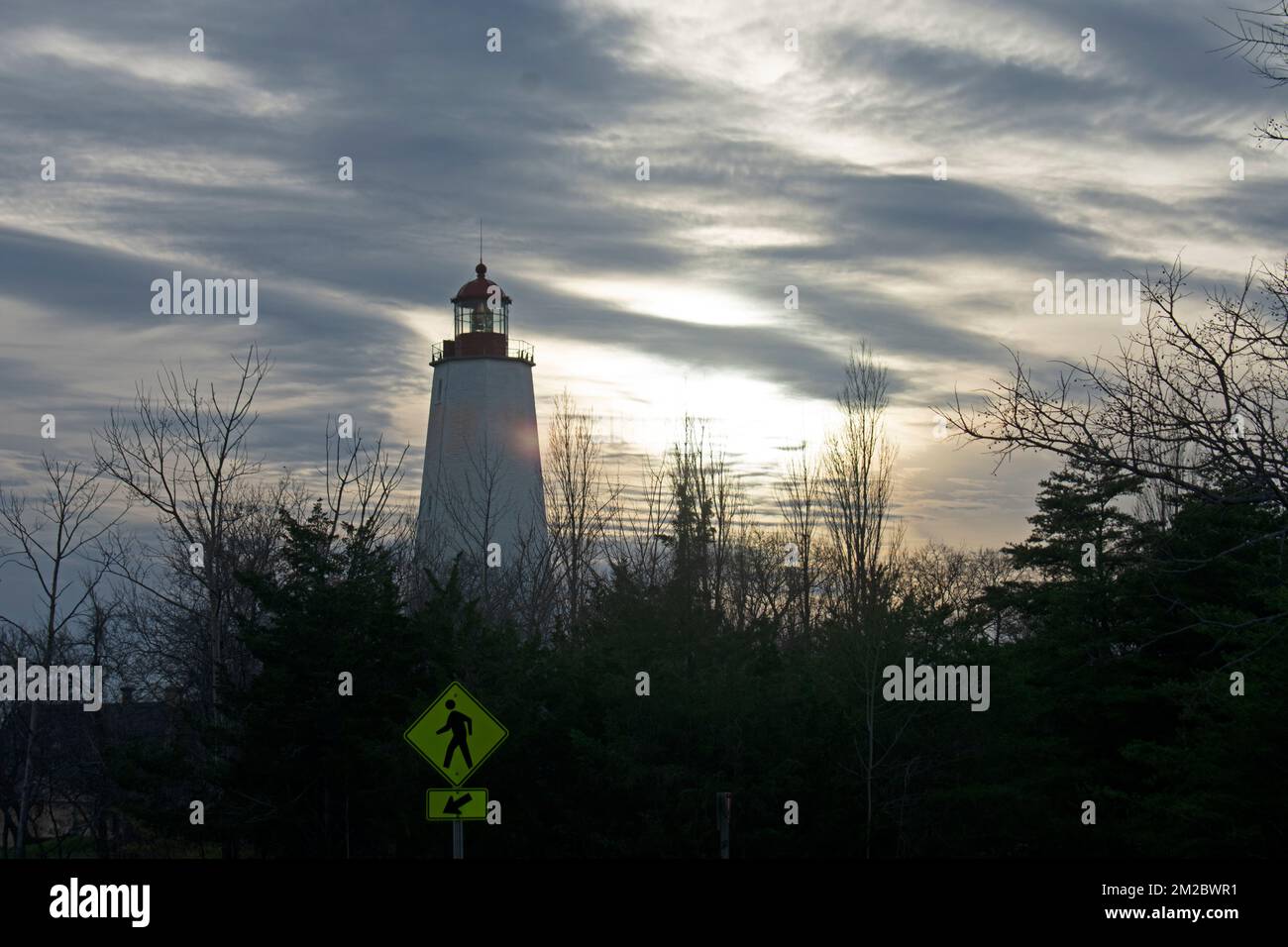 Sandy Hook Faro silhouette contro un cielo nuvoloso al tramonto -79 Foto Stock