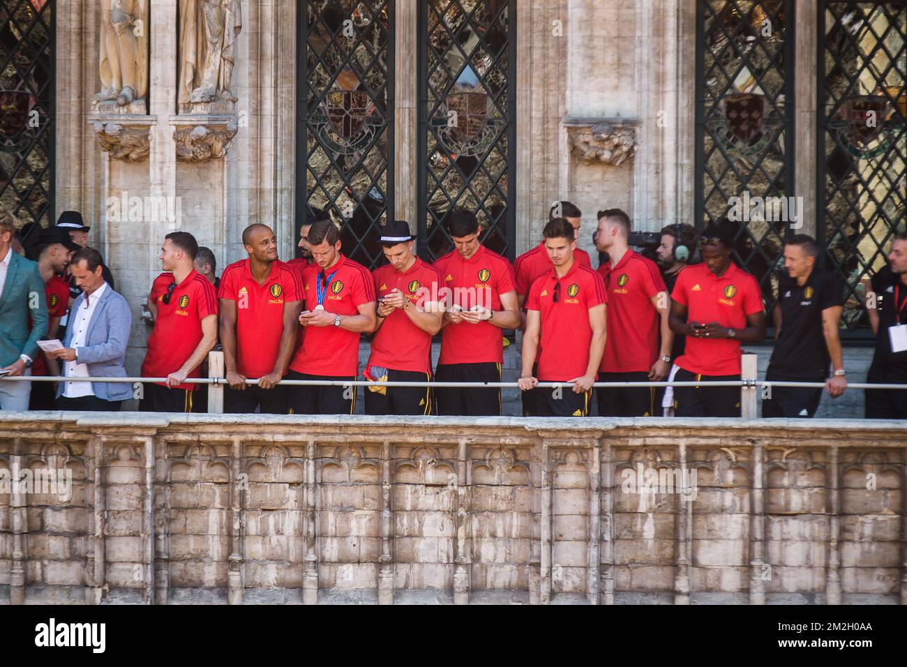 I giocatori controllano i loro smartphone presso la Grand Place-Grote Markt, nel centro di Bruxelles, Mentre la nazionale belga di calcio Red Devils viene a festeggiare con i tifosi sul balcone del municipio dopo aver raggiunto le semifinali e vinto la medaglia di bronzo alla Coppa del mondo di calcio 2018 in Russia, domenica 15 luglio 2018. FOTO DI BELGA JAMES ARTHUR GEKIERE Foto Stock