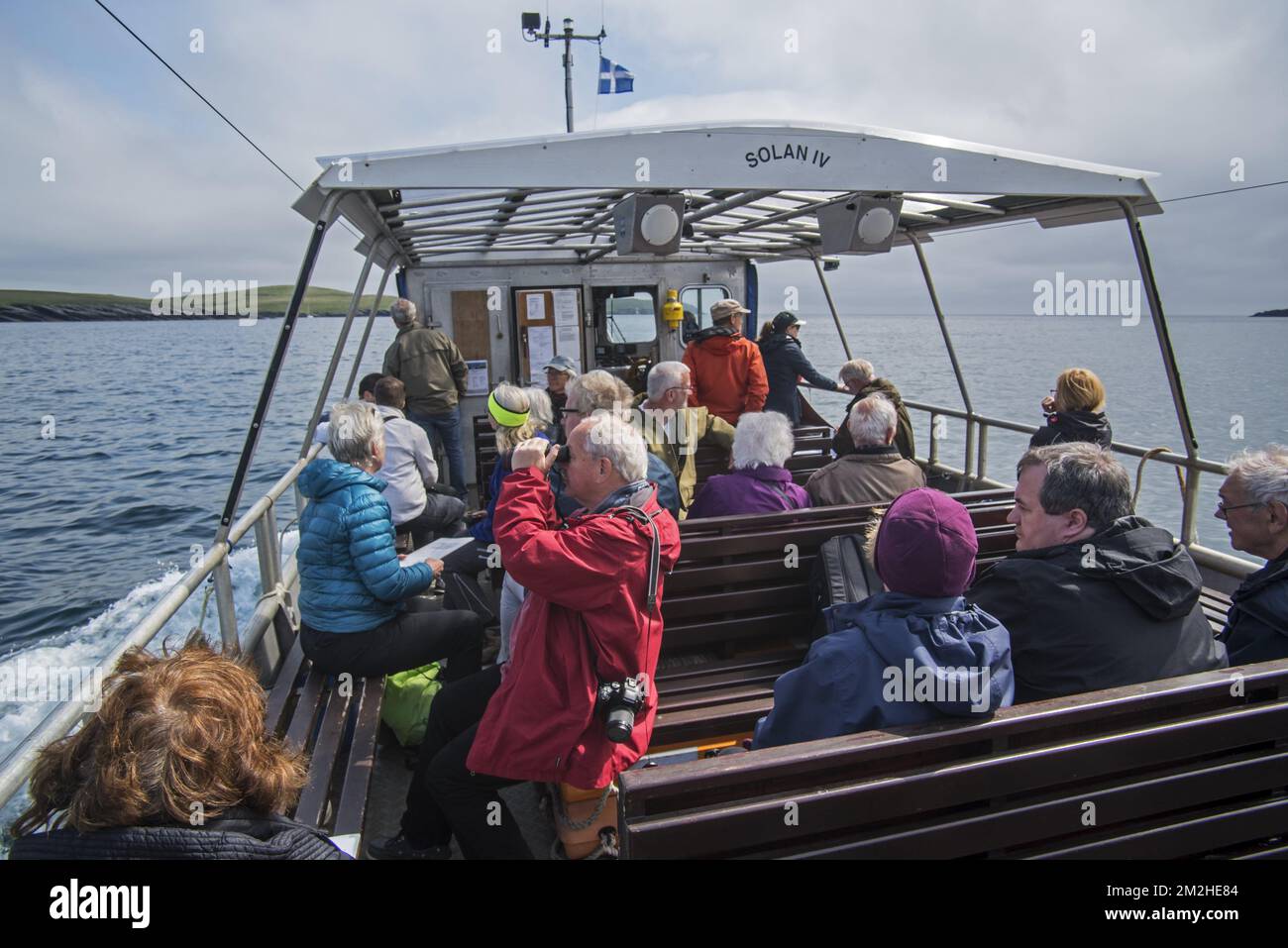 Turisti anziani a bordo del traghetto passeggeri aperto Solan IV da Leebitton a Mousa per osservare uccelli marini, Isole Shetland, Scozia, Regno Unito | Touristes dans le Solan IV, Ferry de Leebitton à Mousa, Shetland, Ecosse 18/06/2018 Foto Stock