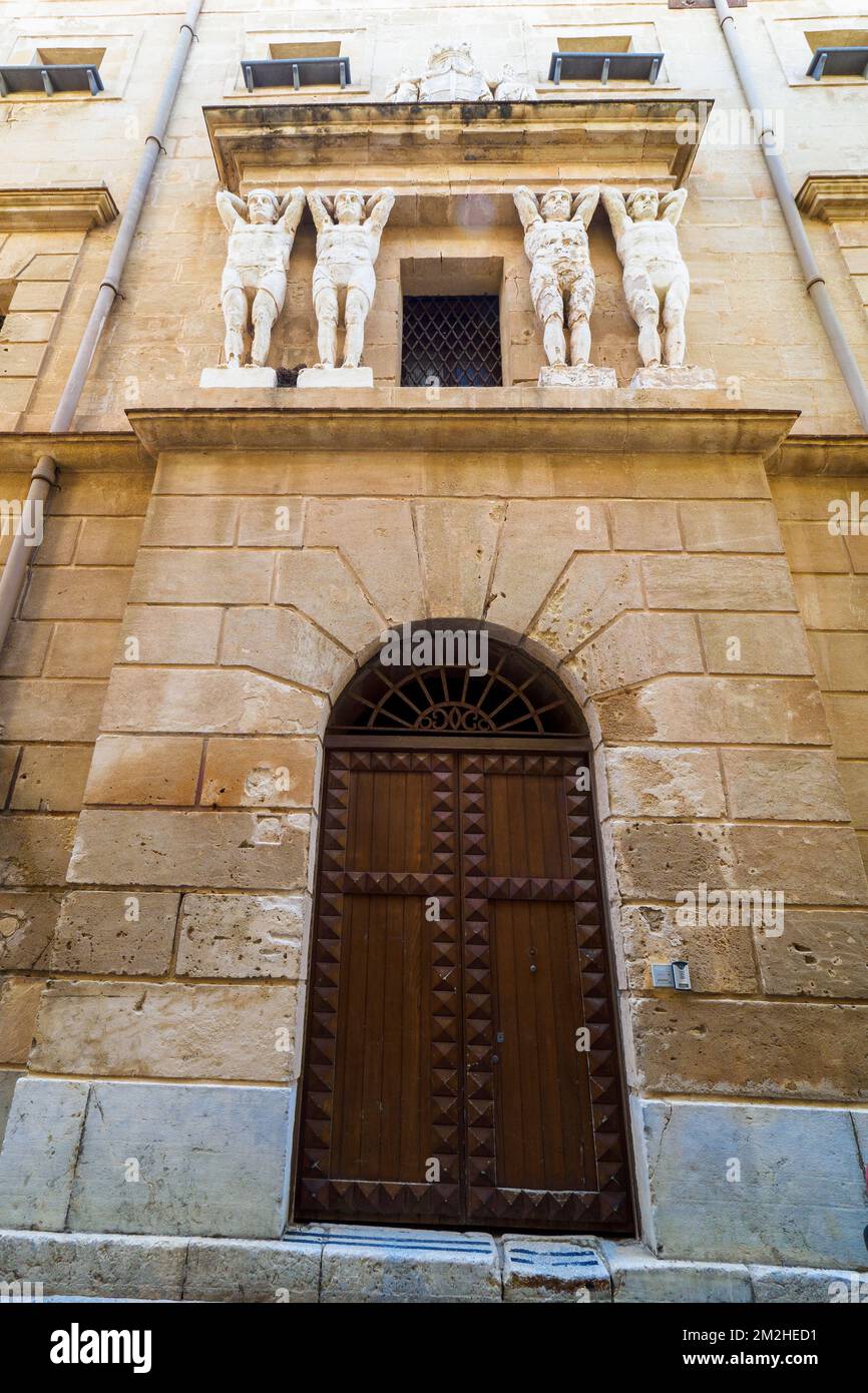 Telamoni a forma di figura maschile al di sopra del portale dell'edificio conosciuto come la 'Vicaria' a Trapani - Sicilia, Italia Foto Stock