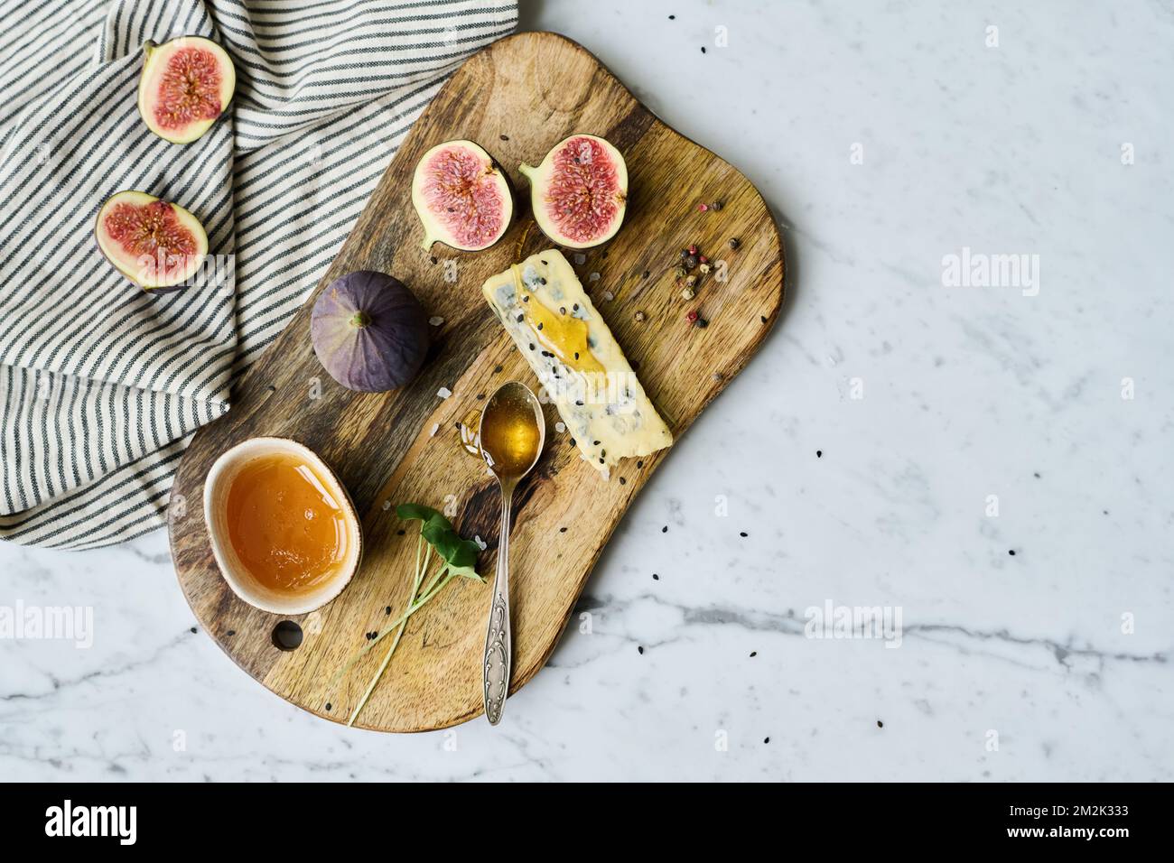 Vista ad angolo alto del vassoio di legno con frutta esotica e miele dolce su di esso in preparazione per le foto Foto Stock