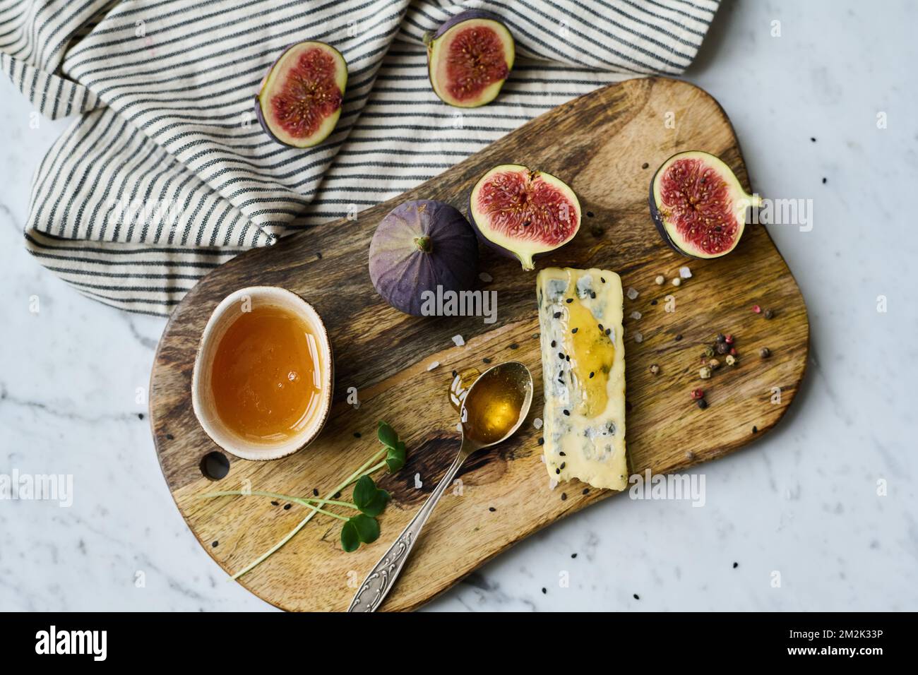 Vista dall'alto dello stile di vita del vassoio di legno con frutta esotica e formaggio con miele Foto Stock