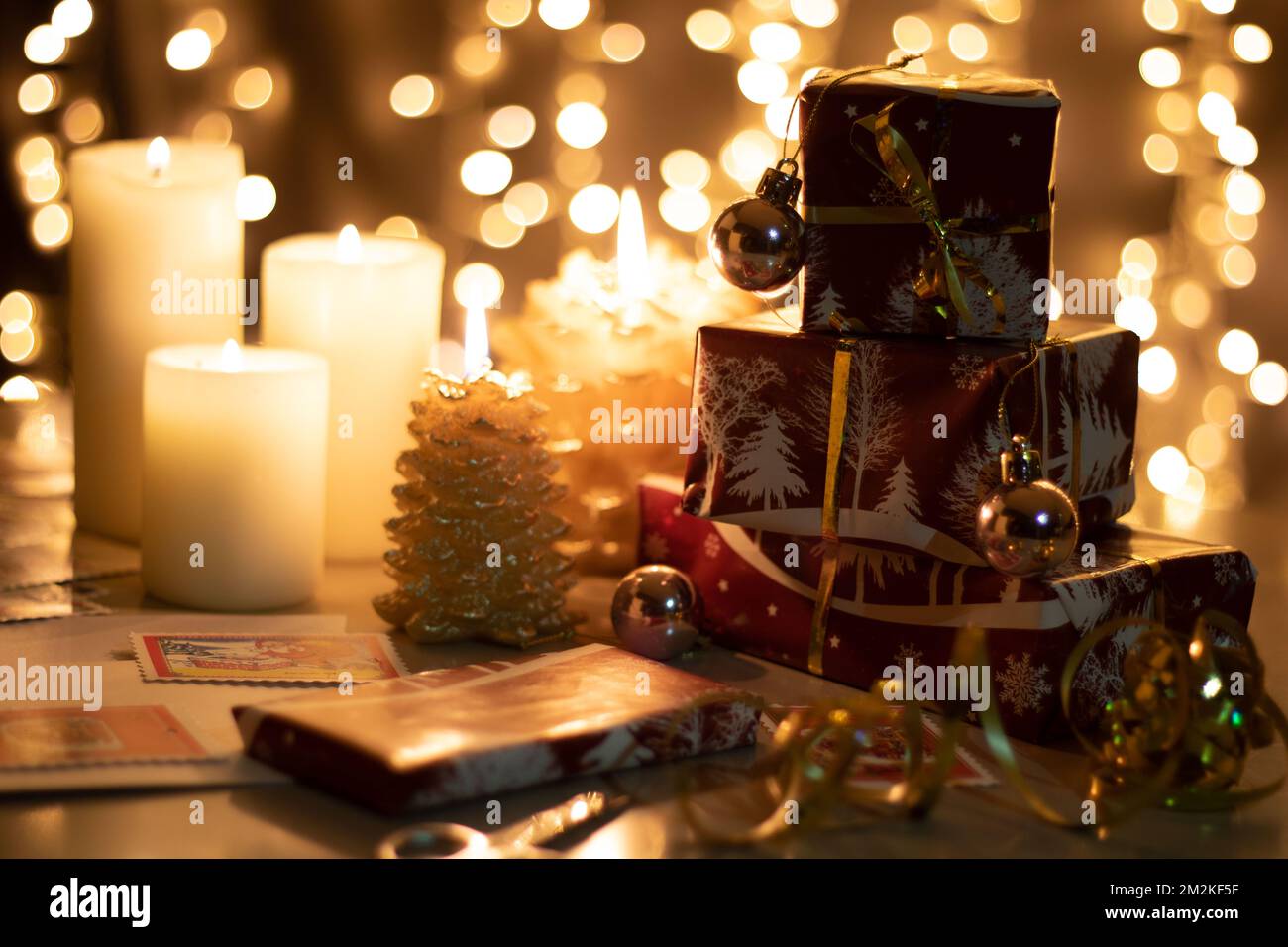 regali fotografici e candele accese sul tavolo Foto Stock