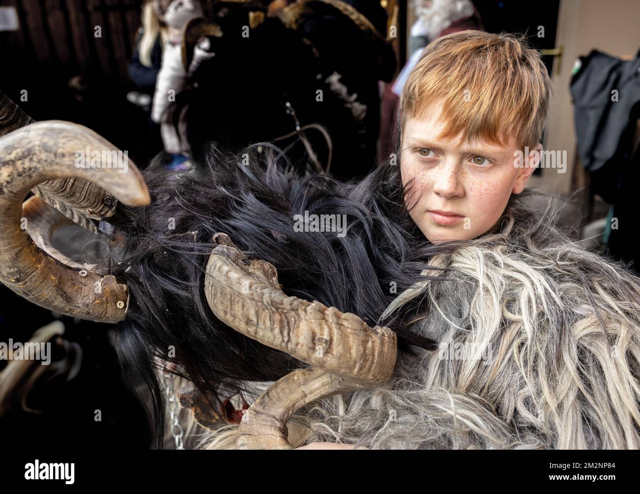Un ragazzo dai capelli rossi con un reckle in costume di Krampus sta in attesa della processione, Austria, Salisburgo Foto Stock