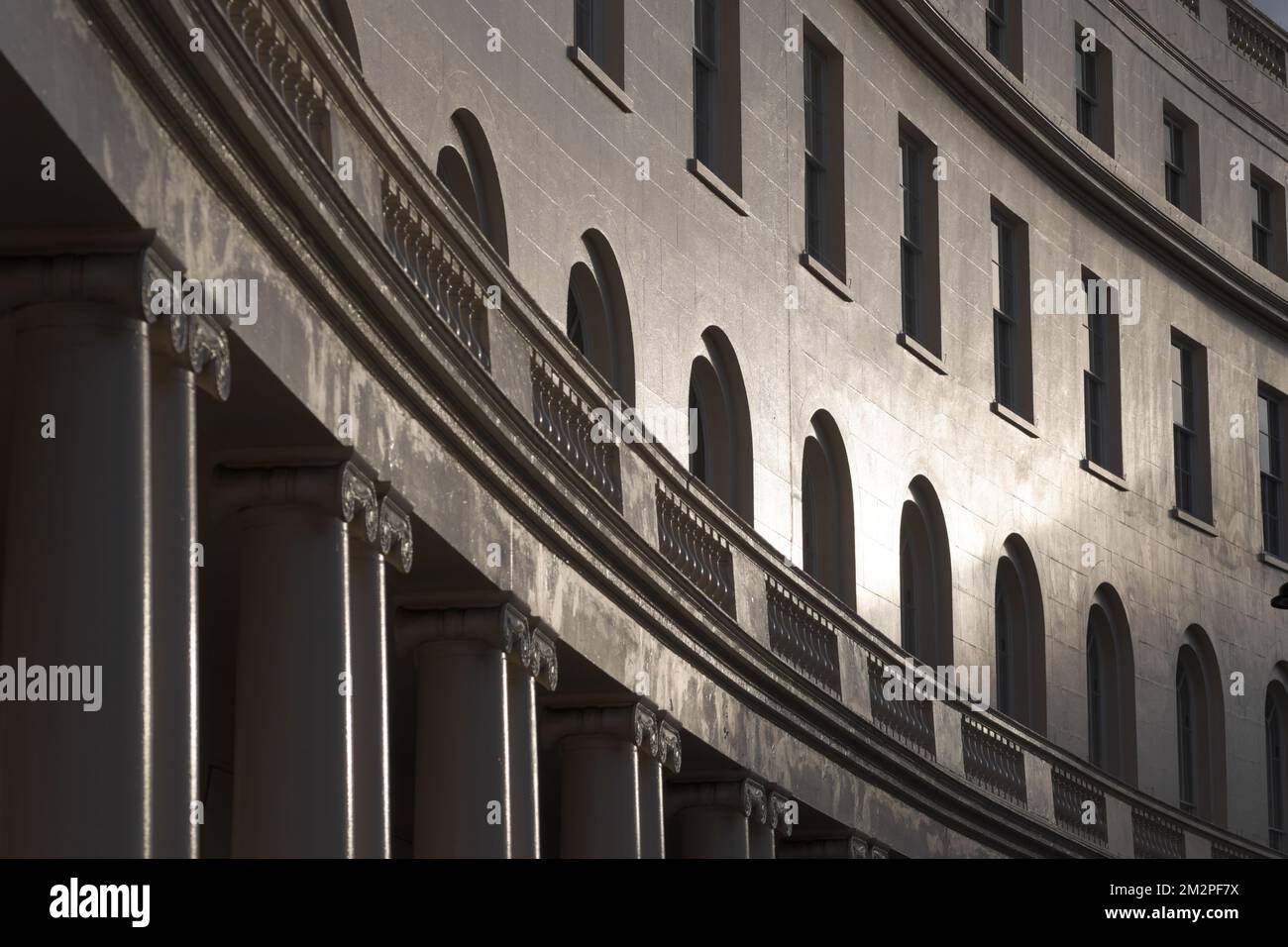 Il tramonto del sole invernale splende sulle curve di un edificio circolare, tranquillità, architettura, tramonto, Londra Foto Stock