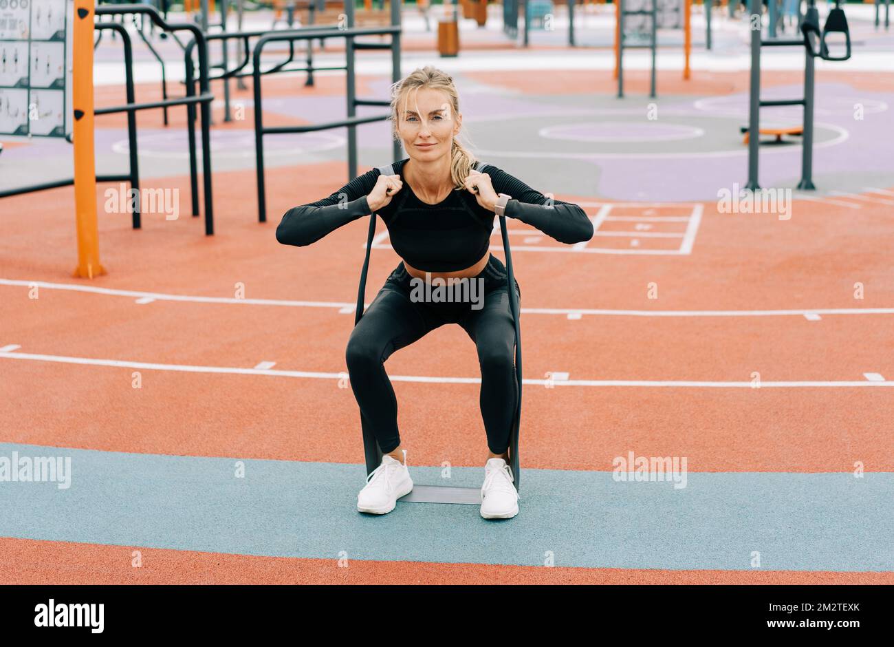 La giovane atletica si sta allenando sul campo sportivo con fasce elastiche sportive. Foto Stock