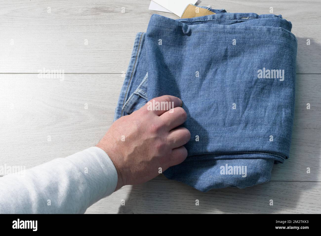 Сhecks la qualità dei pantaloni in denim. Controllare le cose. L'acquirente in negozio Foto Stock