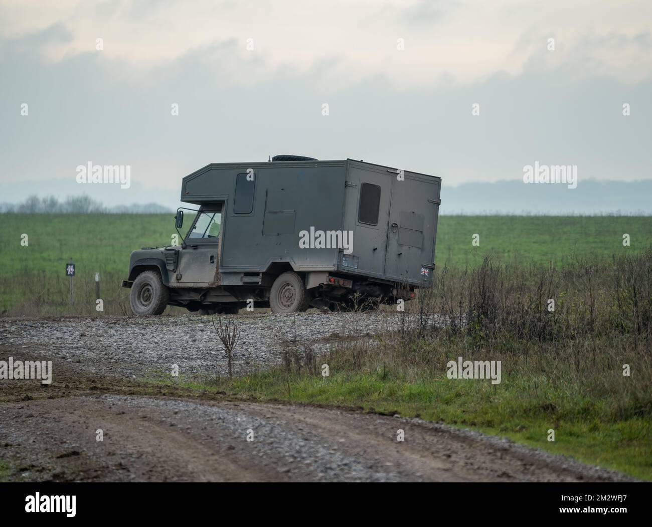 Army Land Rover Wolf convertì un veicolo di assistenza medica leggero che si spostava lungo una pista di fango durante un esercizio militare, Wiltshire UK Foto Stock