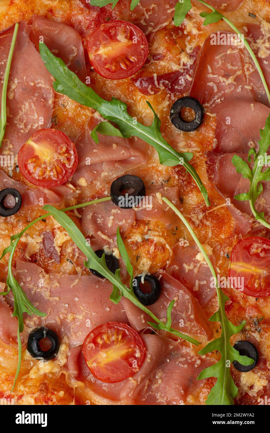 Consistenza della pizza con prosciutto e pomodori Foto Stock