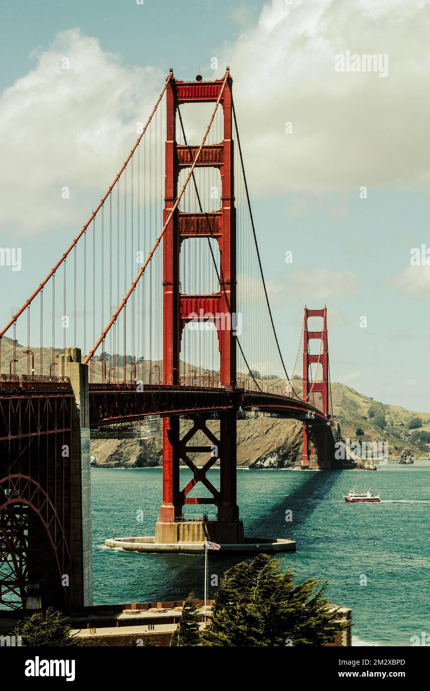 Bellissima immagine del Golden Gate Bridge a San Francisco. Apprezza la scala di questo famoso ponte rispetto a una piccola barca da pesca sottostante. Foto Stock