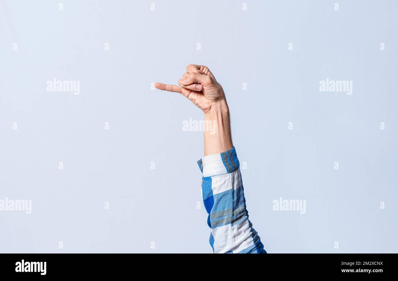 Mano gestendo la lettera J in linguaggio dei segni su uno sfondo isolato. La mano dell'uomo gestendo la lettera J dell'alfabeto isolato. Lettere del Foto Stock