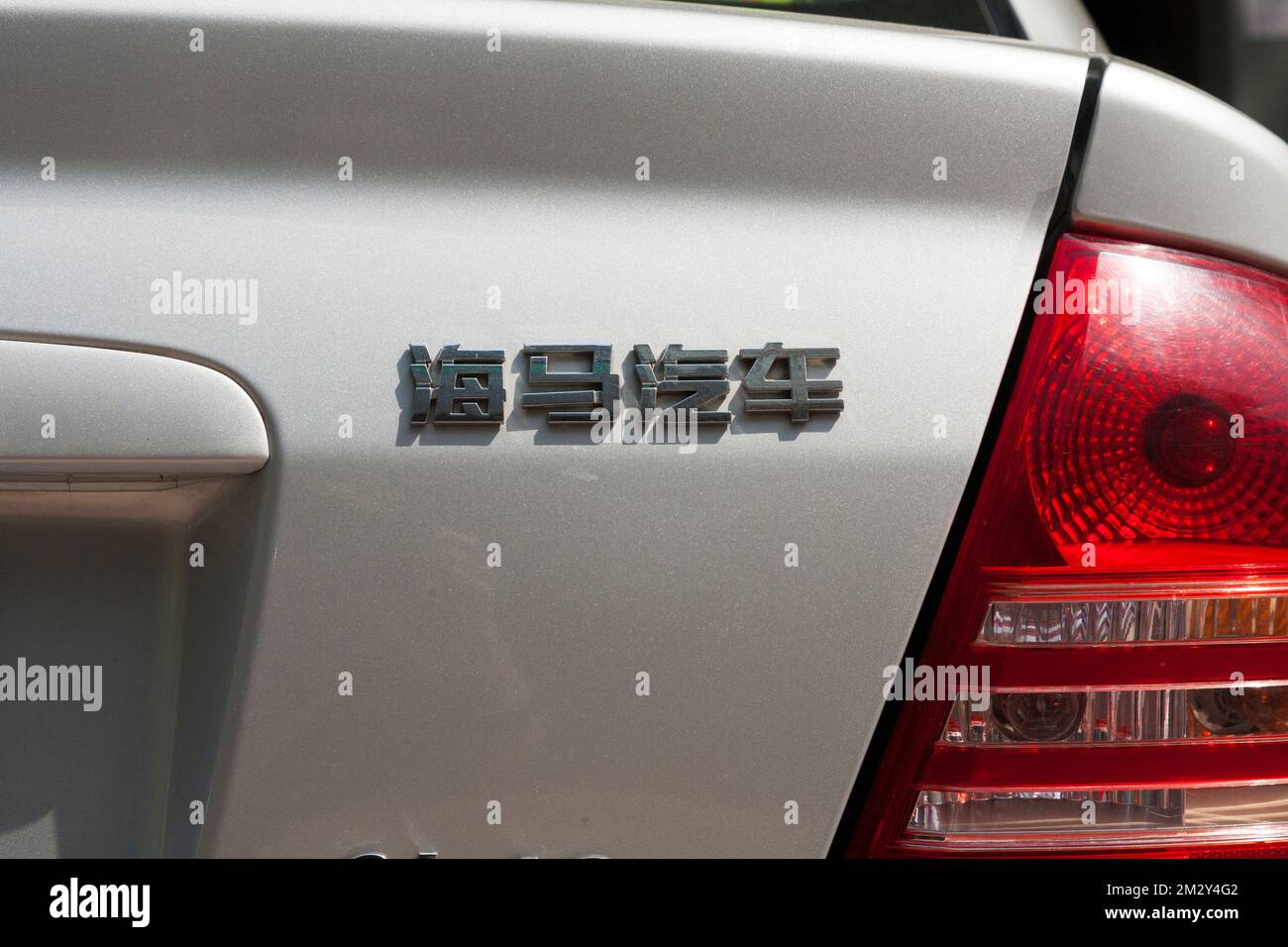 Mazda 323 auto posteriore con sezione di targa e modello scritto in caratteri cinesi / scrivere il nome del modello del veicolo in Cina. Xian, Cina. (125) Foto Stock