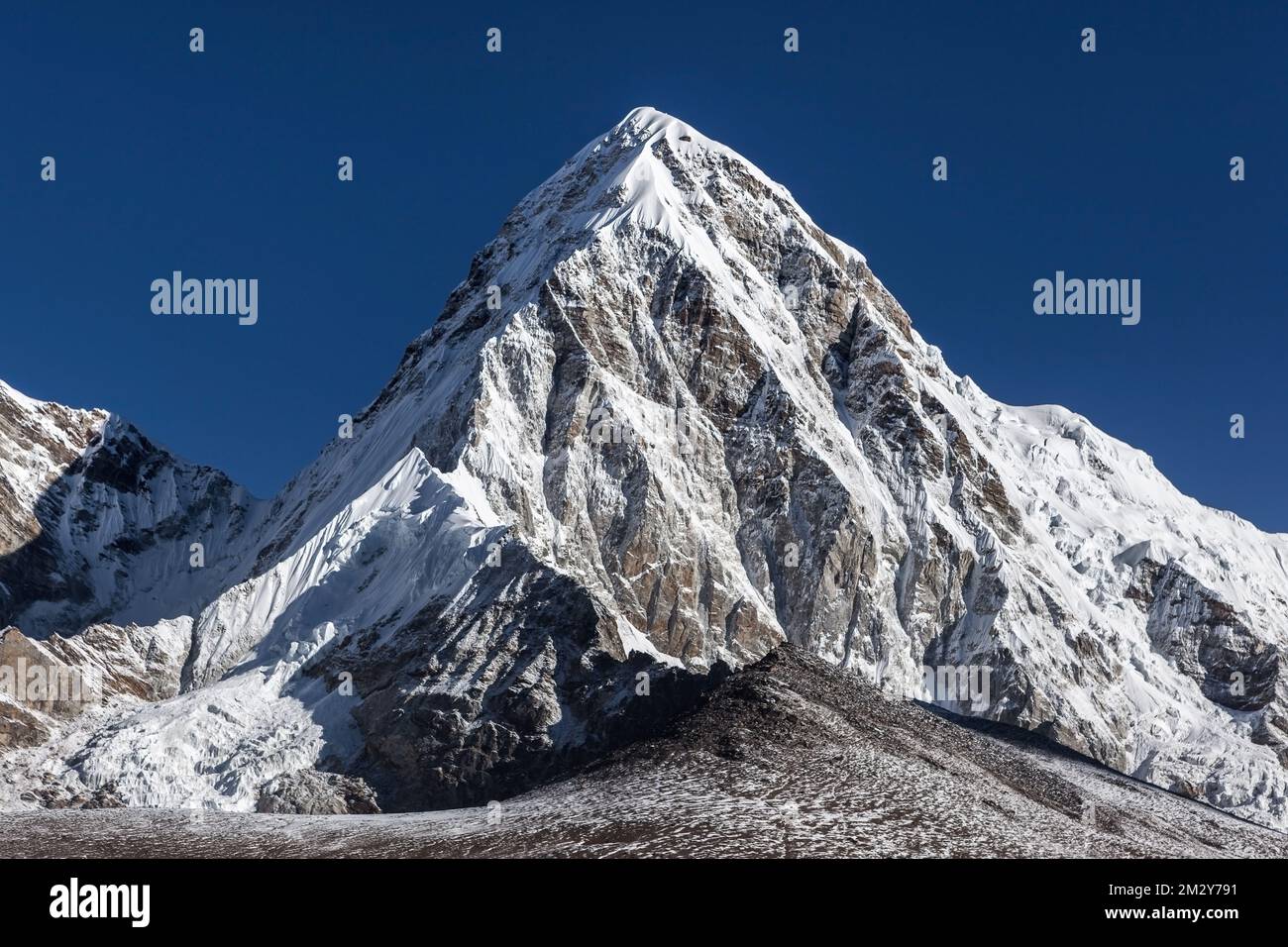 Cima della montagna Pumori nel famoso campo base dell'Everest, trekking sull'Himalaya, Nepal. Vetta innevata in una giornata di sole e sole con cielo limpido. Foto Stock