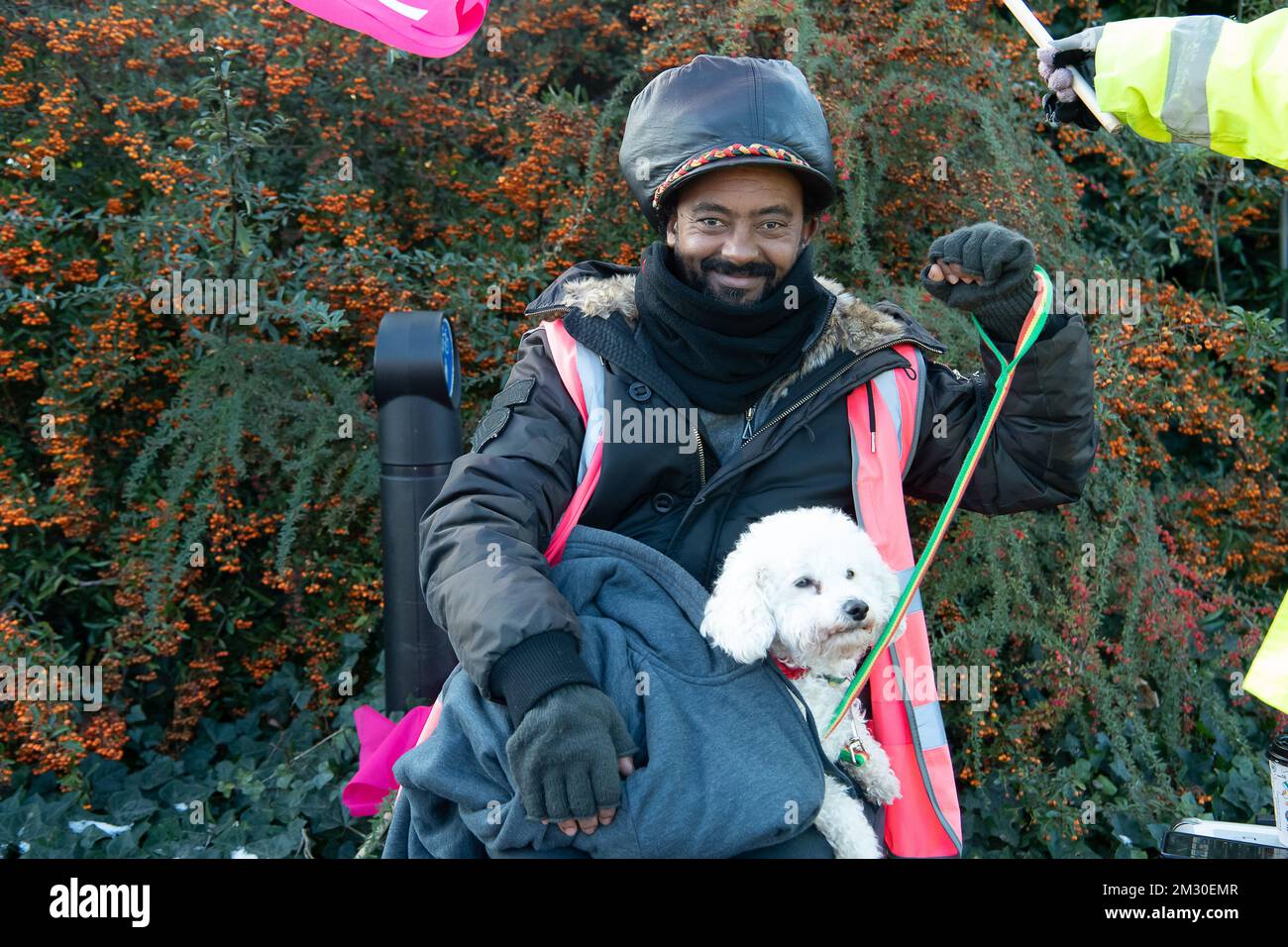 Slough, Berkshire, Regno Unito. 14th dicembre 2022. Un dipendente di Royal Mail e la sua poodle Raffy in sciopero al di fuori dell'ufficio di smistamento di Royal Mail a Slough. I lavoratori della Royal Mail sono stati in sciopero oggi presso l'ufficio di smistamento di Slough in una disputa in corso sulle condizioni salariali e di lavoro. I membri della CWU hanno tenuto un picket ufficiale fuori dall'ufficio di smistamento, tuttavia, i manager e il personale dell'agenzia sono stati portati per continuare a consegnare la posta ai clienti. Credit: Maureen McLean/Alamy Live News Foto Stock