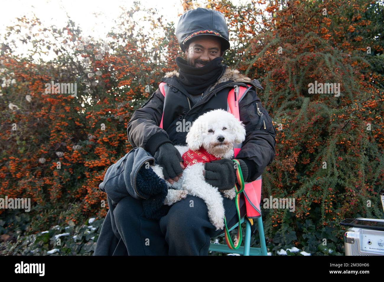 Slough, Berkshire, Regno Unito. 14th dicembre 2022. Un dipendente di Royal Mail e la sua poodle Raffy in sciopero al di fuori dell'ufficio di smistamento di Royal Mail a Slough. I lavoratori della Royal Mail sono stati in sciopero oggi presso l'ufficio di smistamento di Slough in una disputa in corso sulle condizioni salariali e di lavoro. I membri della CWU hanno tenuto un picket ufficiale fuori dall'ufficio di smistamento, tuttavia, i manager e il personale dell'agenzia sono stati portati per continuare a consegnare la posta ai clienti. Credit: Maureen McLean/Alamy Live News Foto Stock