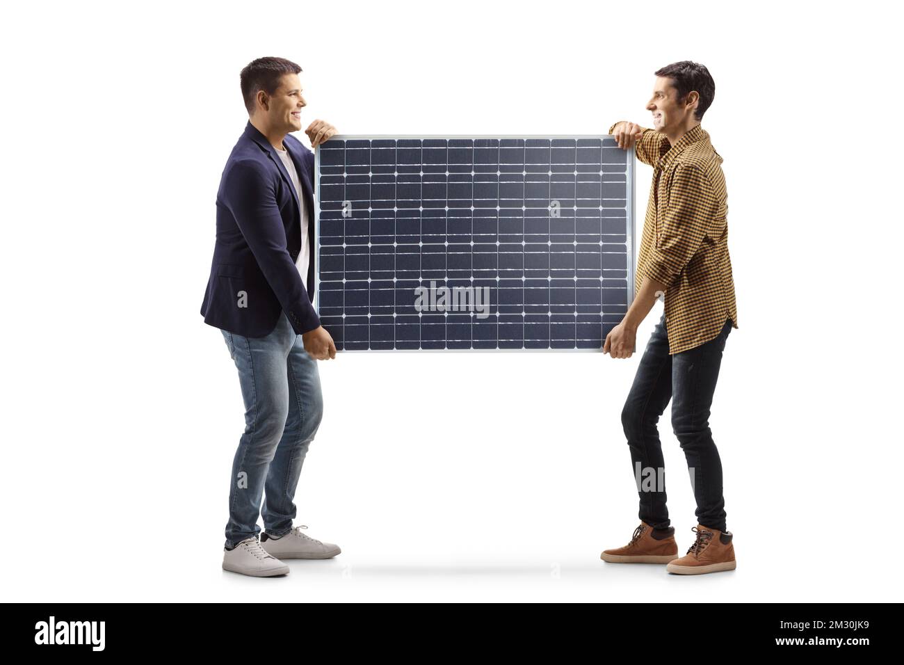 Immagine a profilo completo di due giovani uomini che trasportano un pannello solare isolato su sfondo bianco Foto Stock