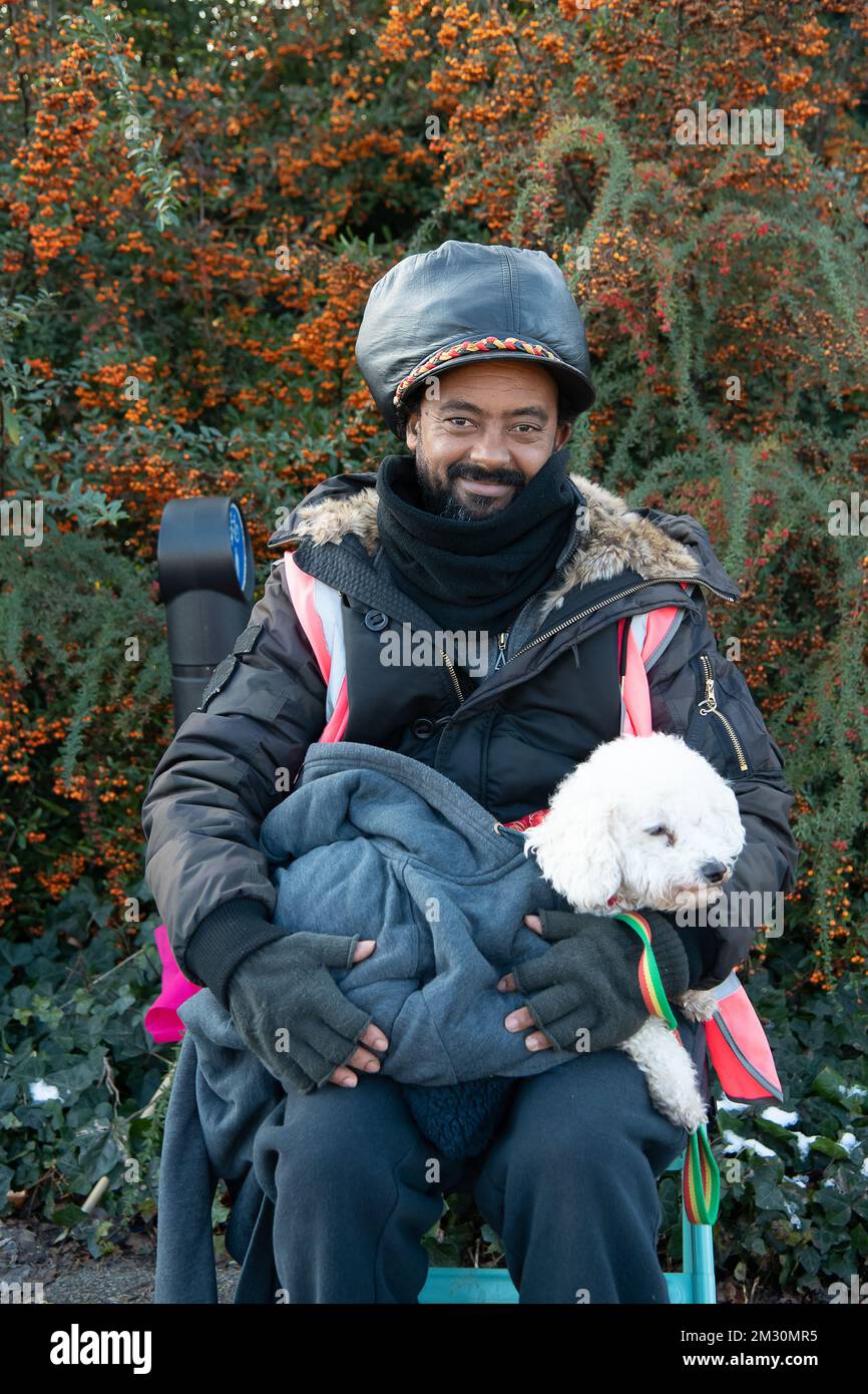 Slough, Berkshire, Regno Unito. 14th dicembre 2022. Un dipendente di Royal Mail e la sua poodle Raffy in sciopero al di fuori dell'ufficio di smistamento di Royal Mail a Slough. I lavoratori della Royal Mail sono stati in sciopero oggi presso l'ufficio di smistamento di Slough in una disputa in corso sulle condizioni salariali e di lavoro. I membri della CWU hanno tenuto un picket ufficiale fuori dall'ufficio di smistamento, tuttavia, i manager e il personale dell'agenzia sono stati portati per continuare a consegnare la posta ai clienti. Credit: Maureen McLean/Alamy Live News Foto Stock