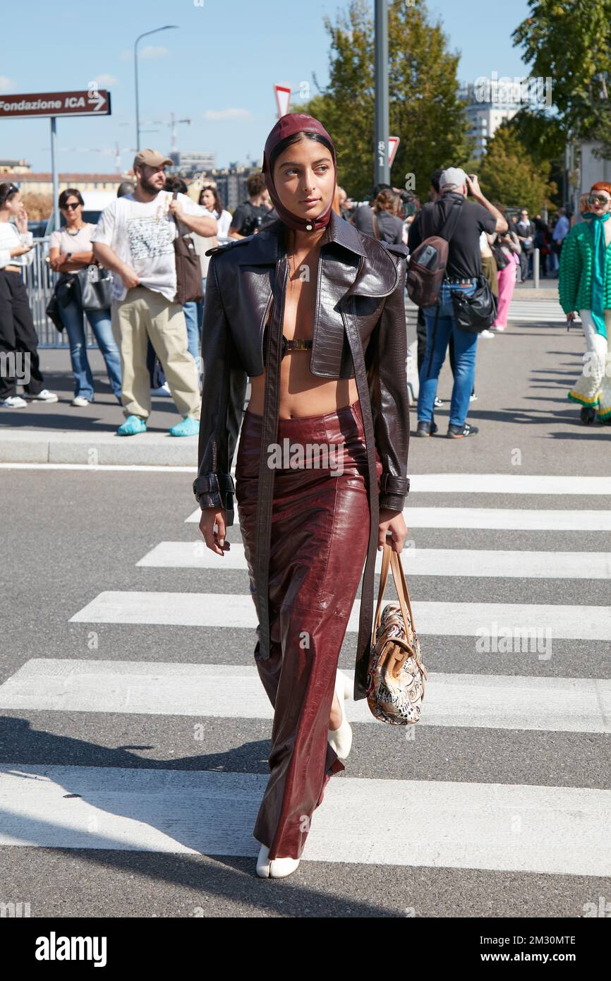 MILANO, ITALIA - 22 SETTEMBRE 2022: Donna con giacca in pelle marrone e gonna  lunga borgogna prima della sfilata Prada, Milano Fashion Week Street Style  Foto stock - Alamy