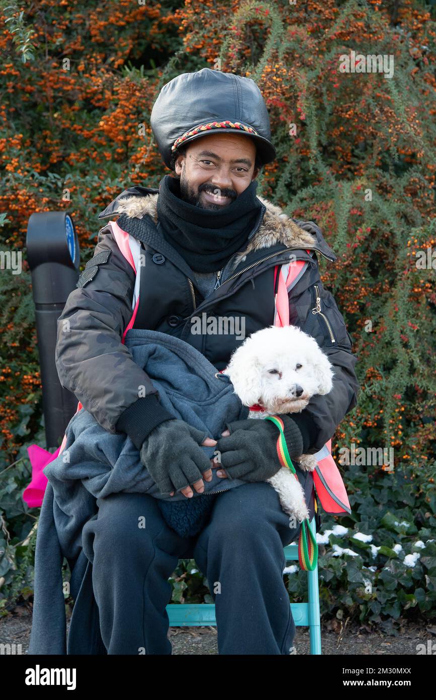 Slough, Berkshire, Regno Unito. 14th dicembre 2022. Un dipendente di Royal Mail e la sua poodle Raffy in sciopero al di fuori dell'ufficio di smistamento di Royal Mail a Slough. I lavoratori della Royal Mail sono stati in sciopero oggi presso l'ufficio di smistamento di Slough in una disputa in corso sulle condizioni salariali e di lavoro. I membri della CWU hanno tenuto un picket ufficiale fuori dall'ufficio di smistamento, tuttavia, i manager e il personale dell'agenzia sono stati portati per continuare a consegnare la posta ai clienti. Credit: Maureen McLean/Alamy Live News Foto Stock