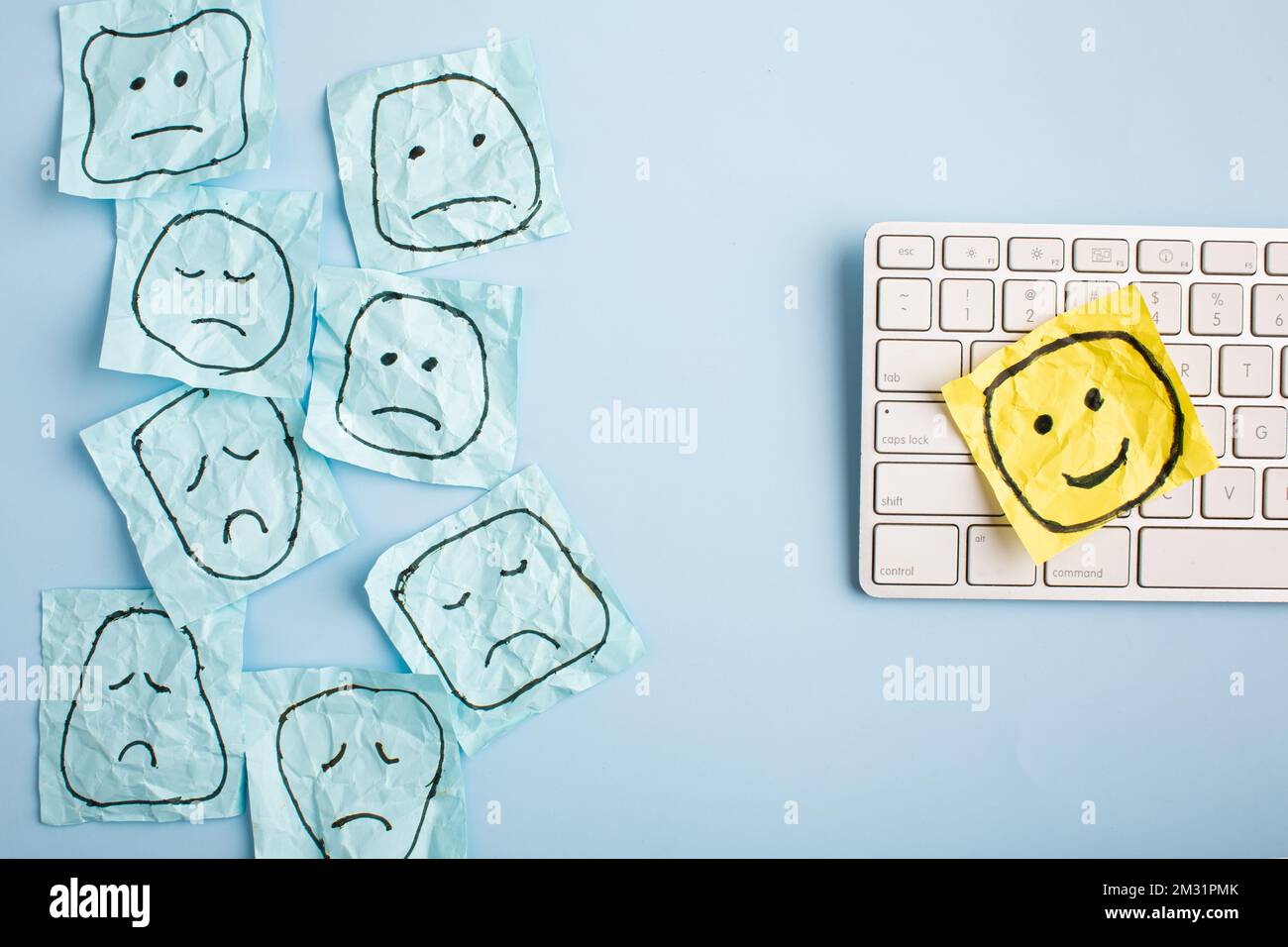 Un volto triste che guarda i volti sorridenti da lontano. Volti felici e tristi disegnati su adesivi blu. Concetti di esclusione, differenza, gelosia. Alta qualità pho Foto Stock