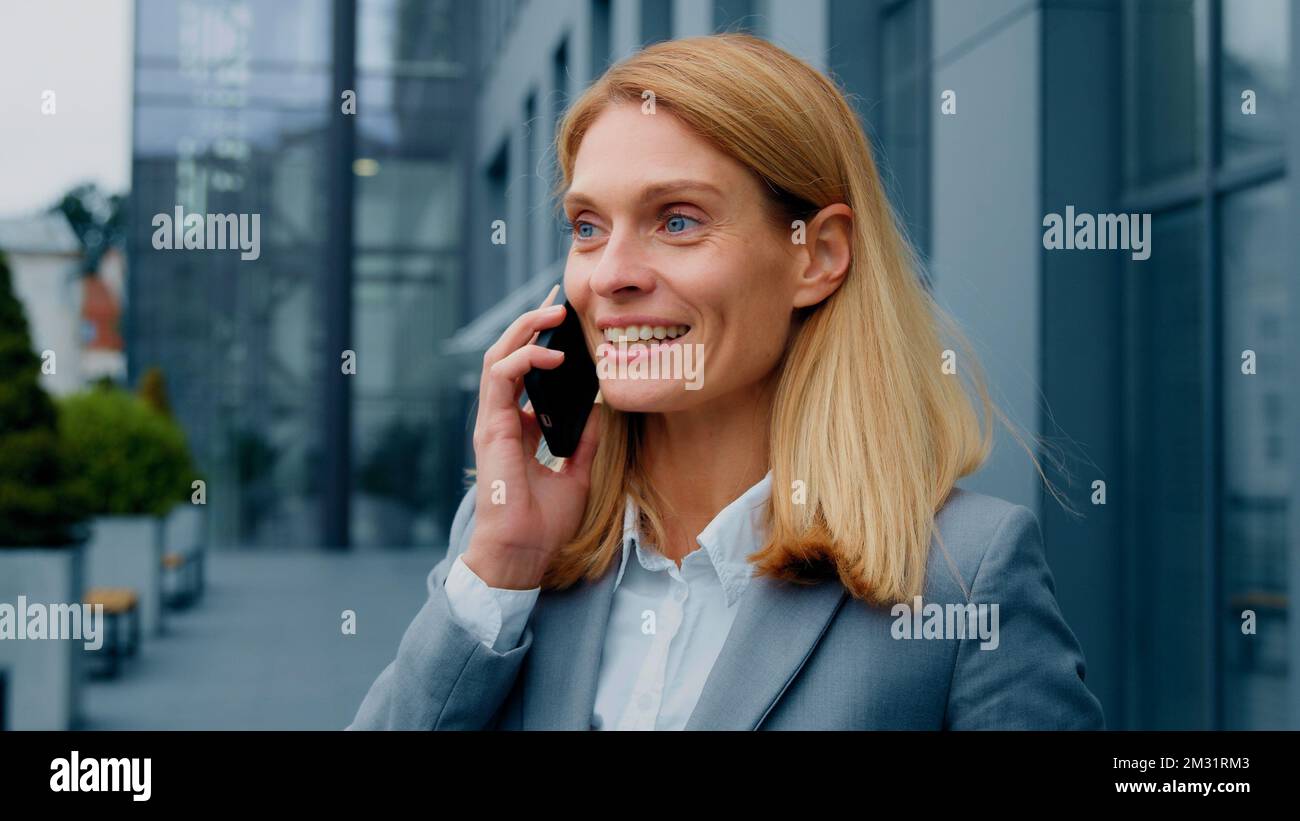 Felice entusiasta donna entusiasta di parlare sul telefono cellulare all'aperto condividere una buona esperienza con gli amici in remoto chattare su smartphone gioioso Foto Stock