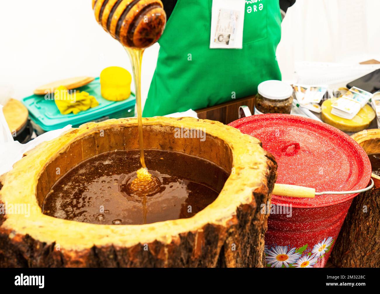 Cucchiaio di miele sepolto in un barile di fragrante miele fresco. Primo piano, concetto di alimentazione sana. Foto Stock