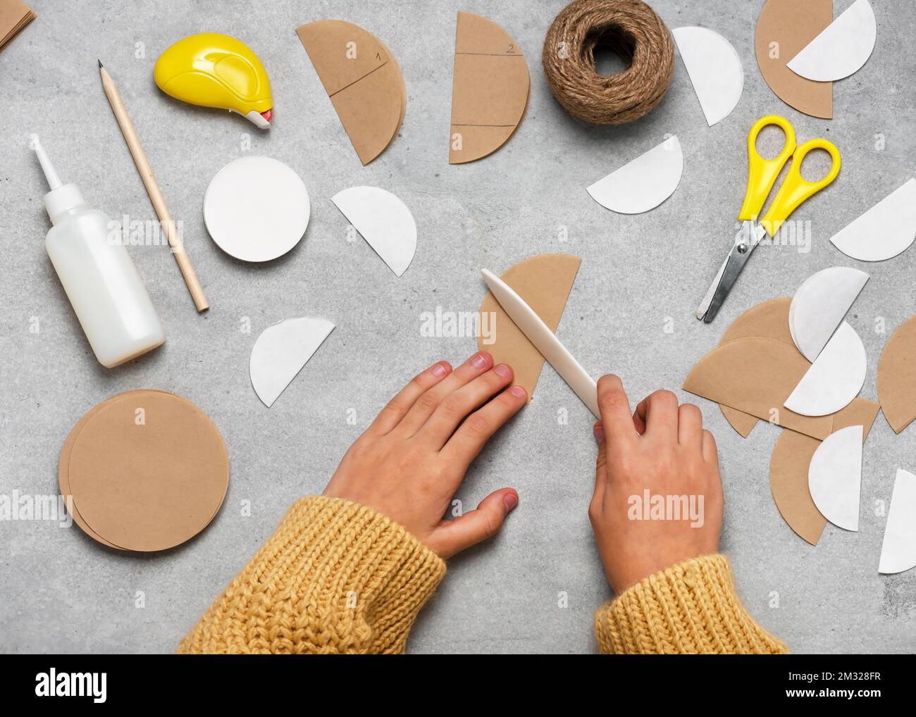 Passaggio 2. Piegare tutti i cerchi a metà. Realizzazione di palline Honeycomb in carta da filtro per caffè per Natale. Attività stagionale con bambini. Vista dall'alto. Foto Stock