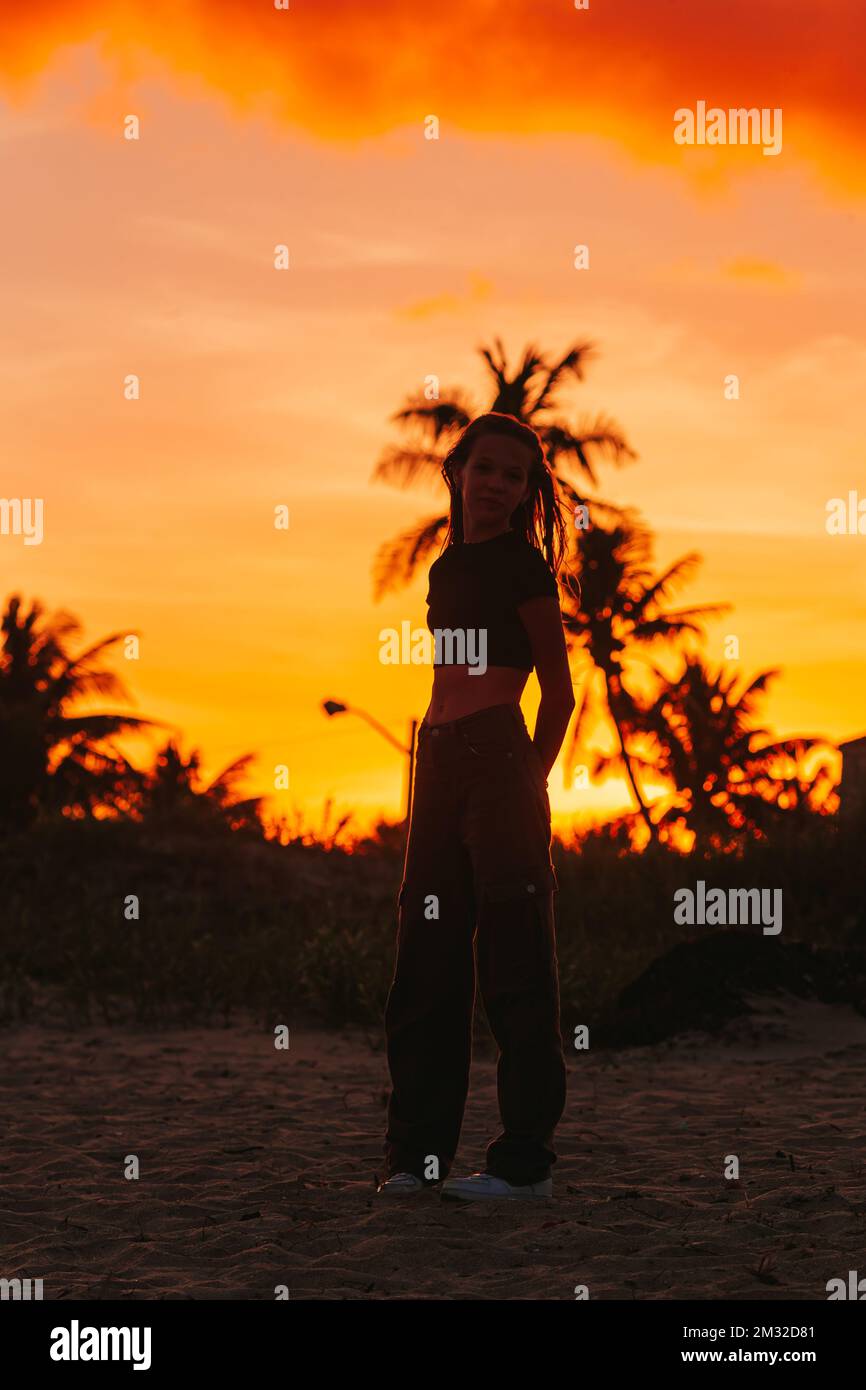Ragazza bella e graziosa teen sulla riva del mare tropicale al tramonto Foto Stock