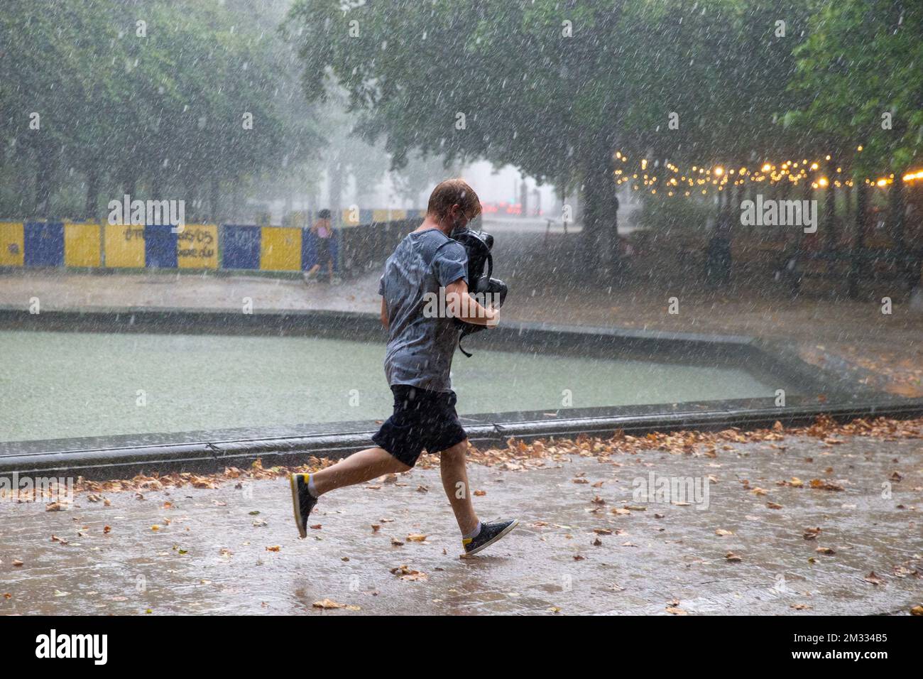 L'immagine mostra un uomo che corre per la copertura, in caso di forti precipitazioni, al Warandepark - Parc de Bruxelles, a Bruxelles, domenica 16 agosto 2020. Il Royal Meteorological Institute KMI - IRM ha classificato la situazione 'codice arancione' con forti precipitazioni e temporali in tutto il paese. FOTO DI BELGA NICOLAS MAETERLINCK Foto Stock