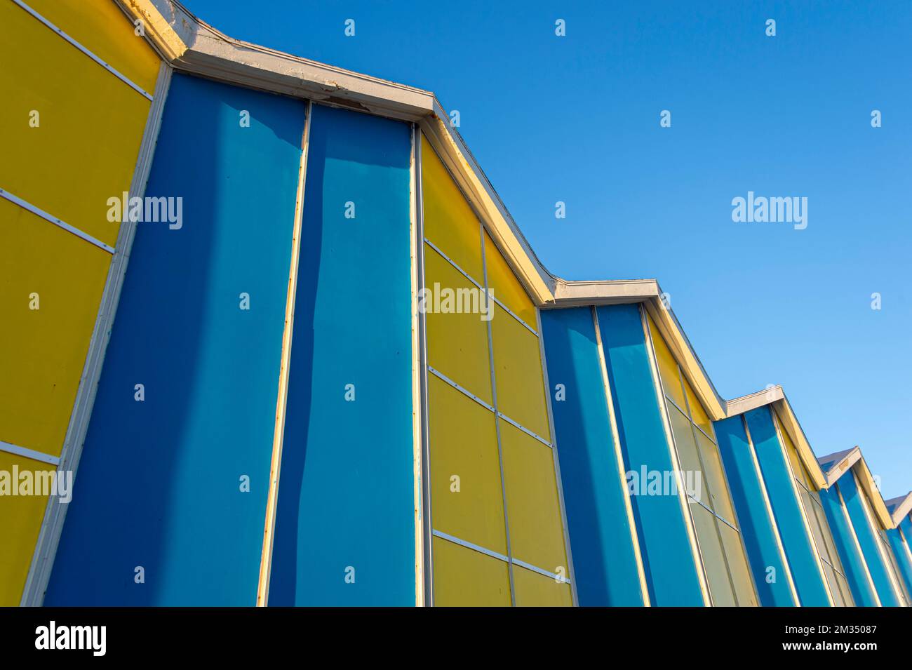 Edificio blu e giallo contro un cielo blu chiaro Foto Stock