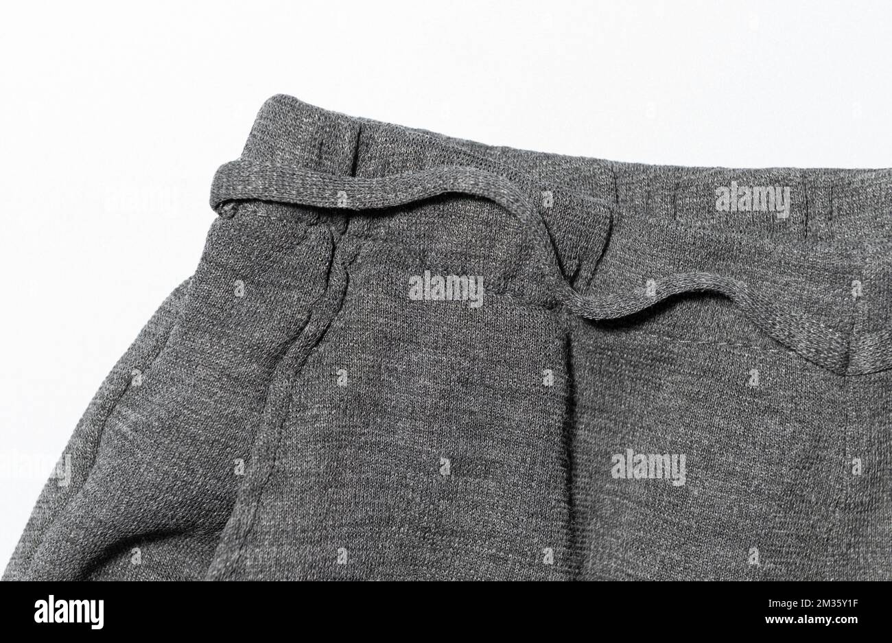 Maglia spessa. La texture del tessuto dei pantaloni da donna. Primo piano su sfondo bianco Foto Stock