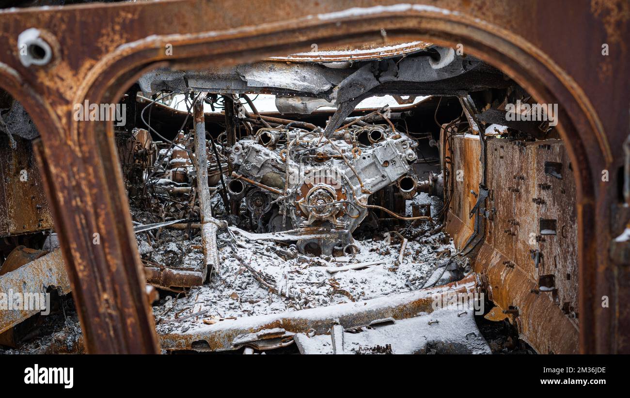 Mirolybivka, regione di Kherson, Ucraina - 12.07.2022: Il motore dei veicoli blindati bruciati dell'esercito russo nella neve in tonnellate bianche, grigie e rosse Foto Stock