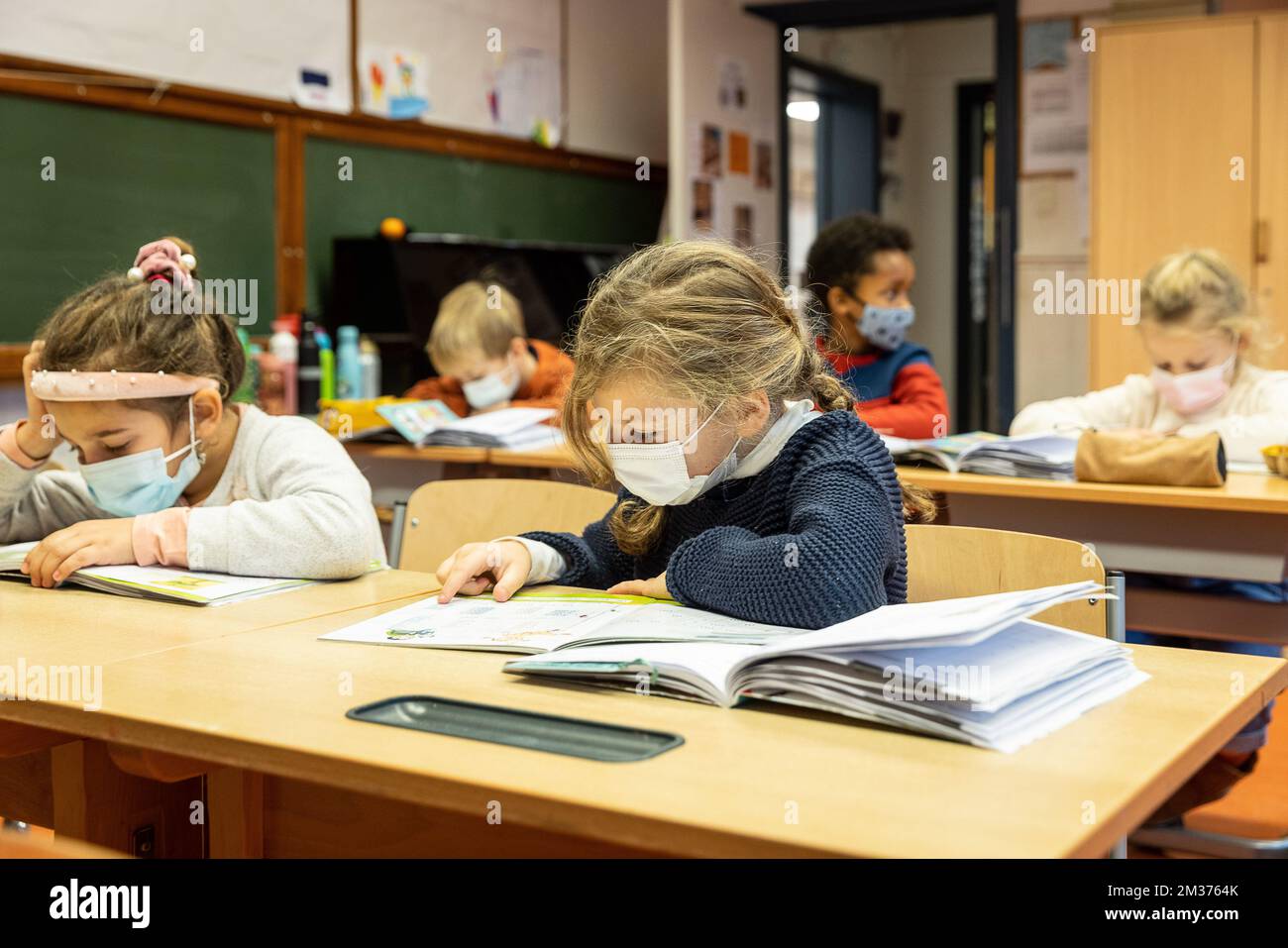 L'illustrazione mostra gli schildren della scuola che indossano le maschere della bocca nella loro classe ad una scuola primaria a Gent, lunedì 06 dicembre 2021. Da oggi, i bambini a partire dai sei anni devono indossare un tappo per la bocca negli spazi pubblici, comprese le scuole. L'obbligo della maschera orale fa parte di nuove e più forti misure di sicurezza e igiene nella pandemia di Covid-19. FOTO DI BELGA JAMES ARTHUR GEKIERE Foto Stock