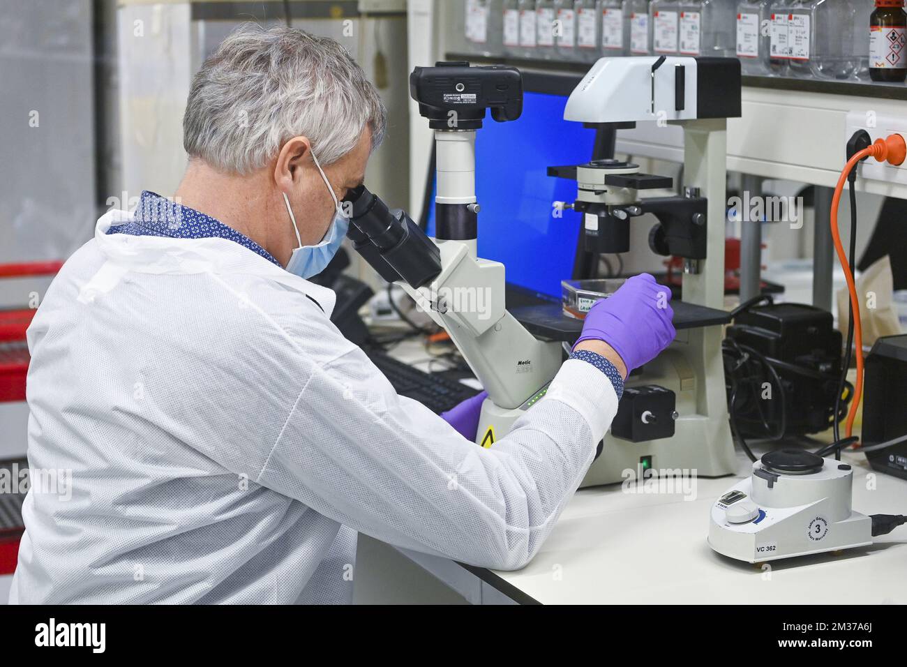 Il belga Johan Neyts, professore di virologia presso il Rega Institute for Medical Research dell'università di KU Leuven, esamina un microscopio, presso il laboratorio, a Leuven mercoledì 15 dicembre 2021. FOTO DI BELGA LAURIE DIEFFEMBACQ Foto Stock