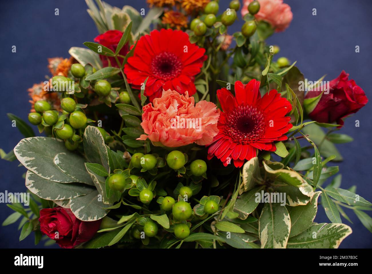 bouquet floreale di gerberie rosse, garofani e verde professionalmente fatto primo piano Foto Stock