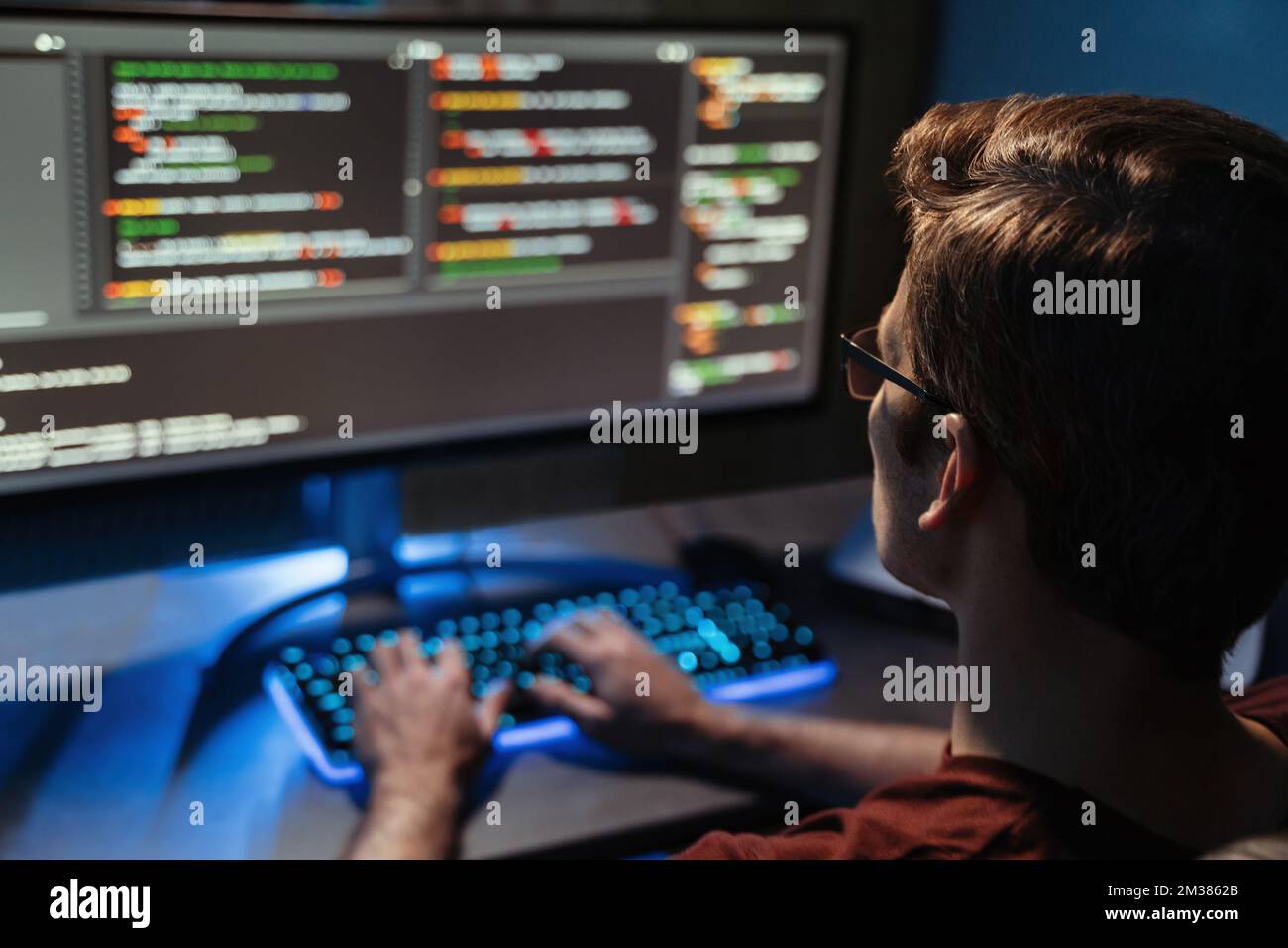 Vista posteriore del codice uomo per la sicurezza informatica, la programmazione e il lavoro da casa tarda notte. Programmatore, codice e libero professionista che lavora allo schermo del pc usando il linguaggio php. Messa a fuoco selettiva Foto Stock